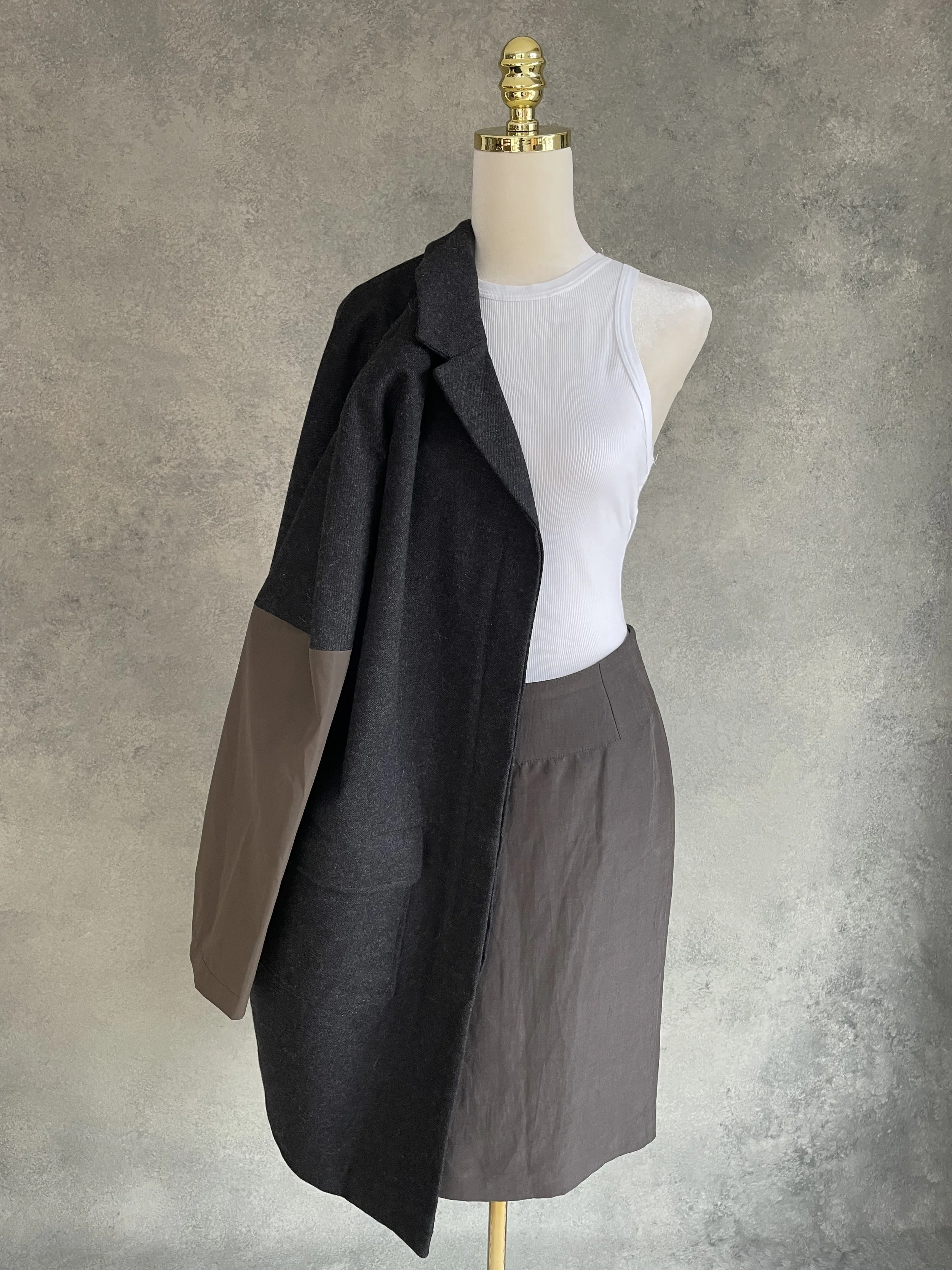 Styling shot showing the Rue Blanche coat draped over one shoulder.