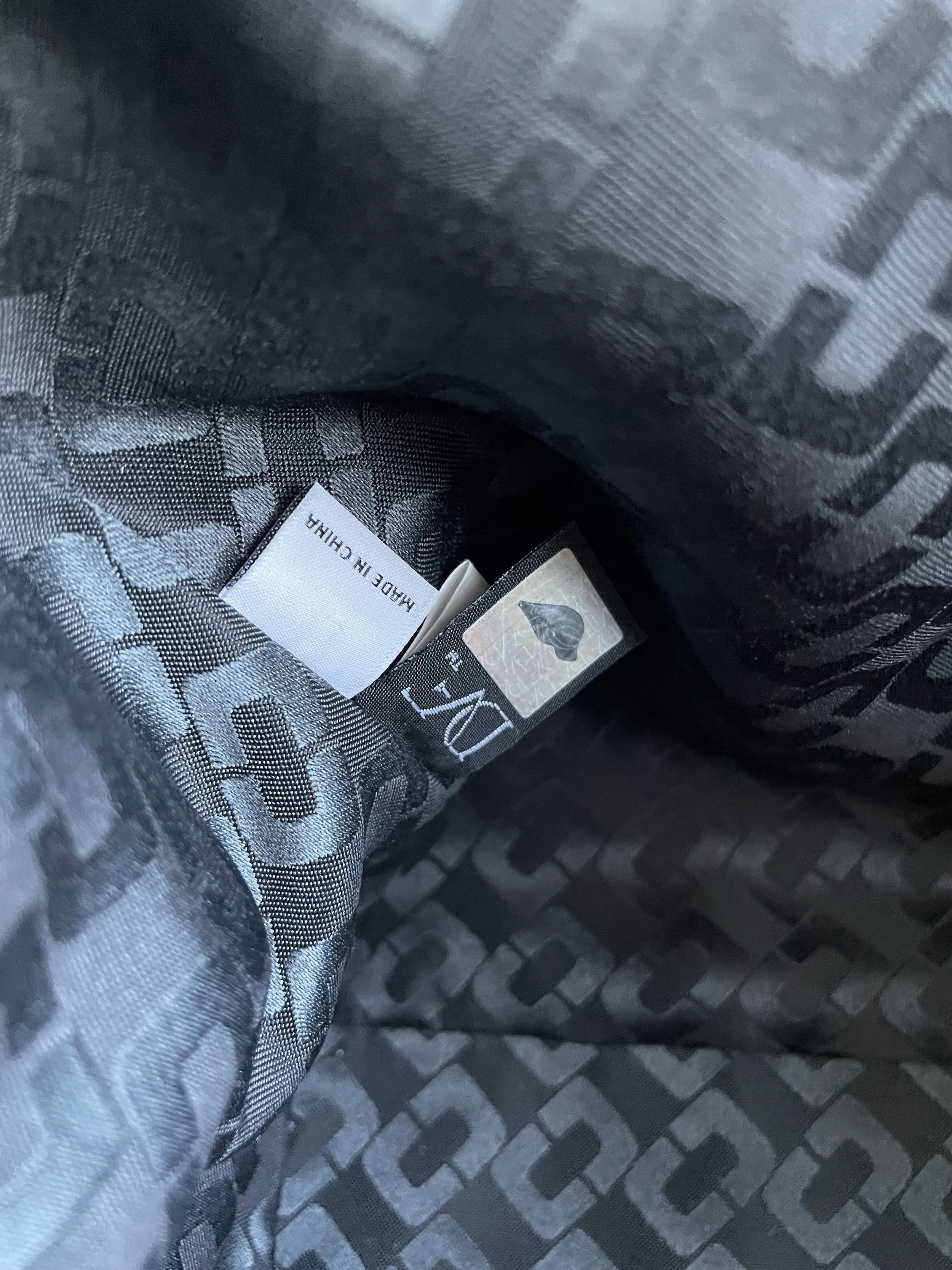 Interior view of the DVF bag showing the monogram-lined fabric and 'Made in China' authenticity tag