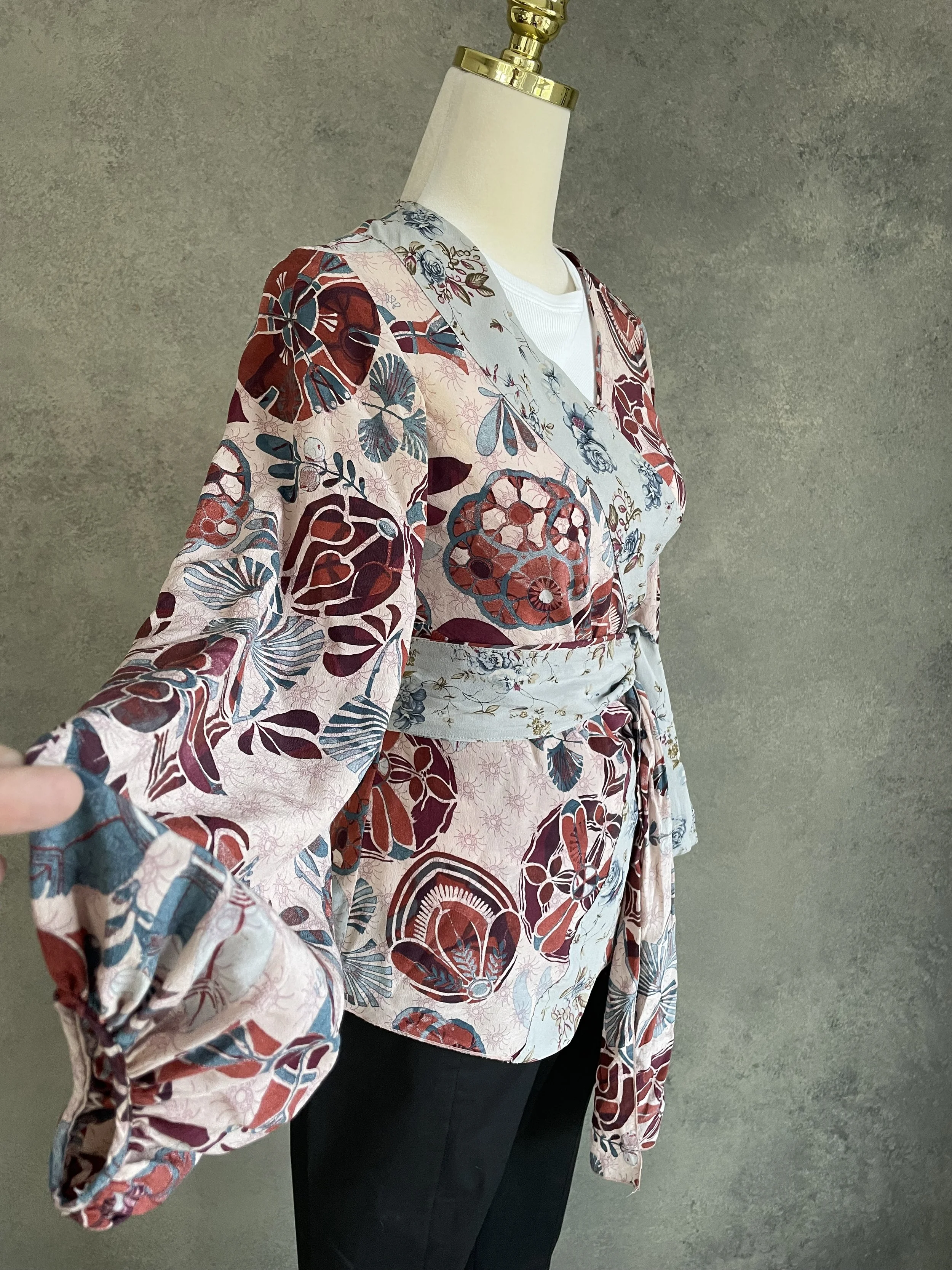 Detail of the Dondup long sleeve, showcasing the complex graphic pattern in burnt red, pink, and teal blue.