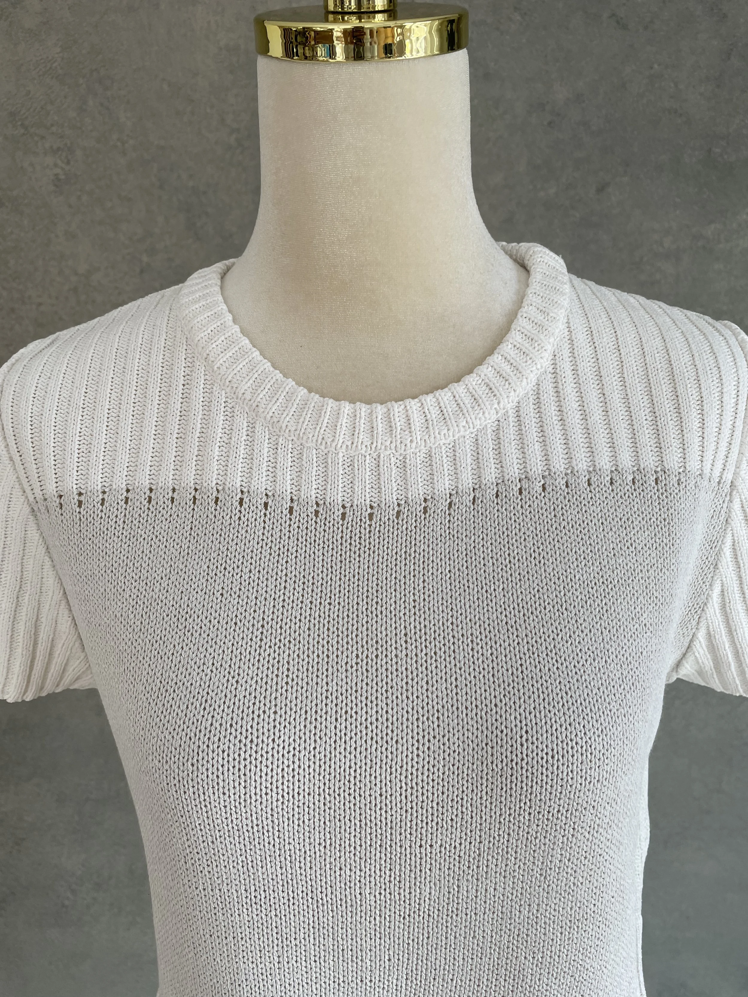 Front view of a Natan beige knit top showing the smooth center panel and ribbed hem and sleeve details.
