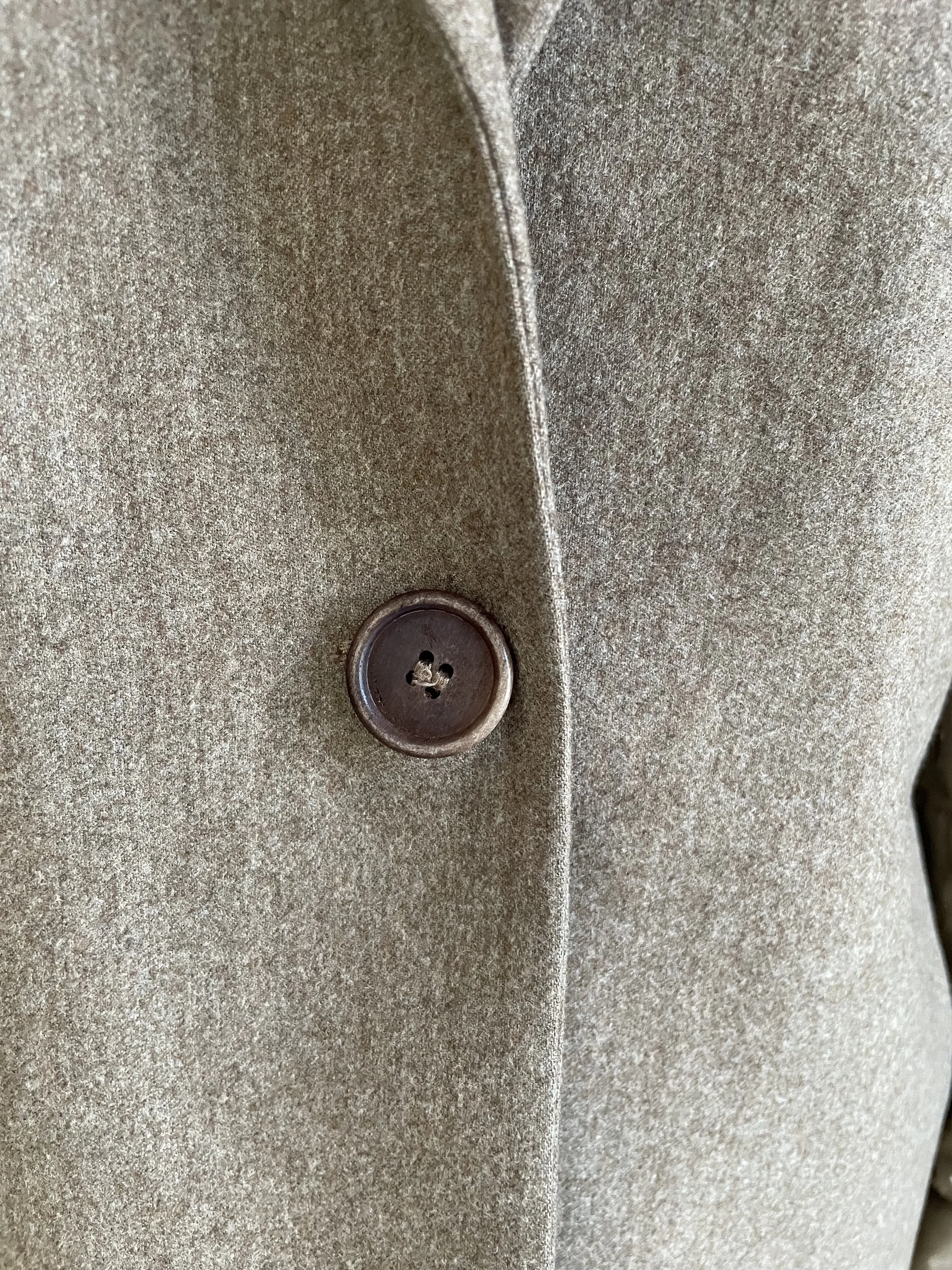 A mid-close-up view focusing on the blazer’s collar, notch lapel, and the shoulder area, showcasing the high-quality finish and the white internal binding visible at the neck.