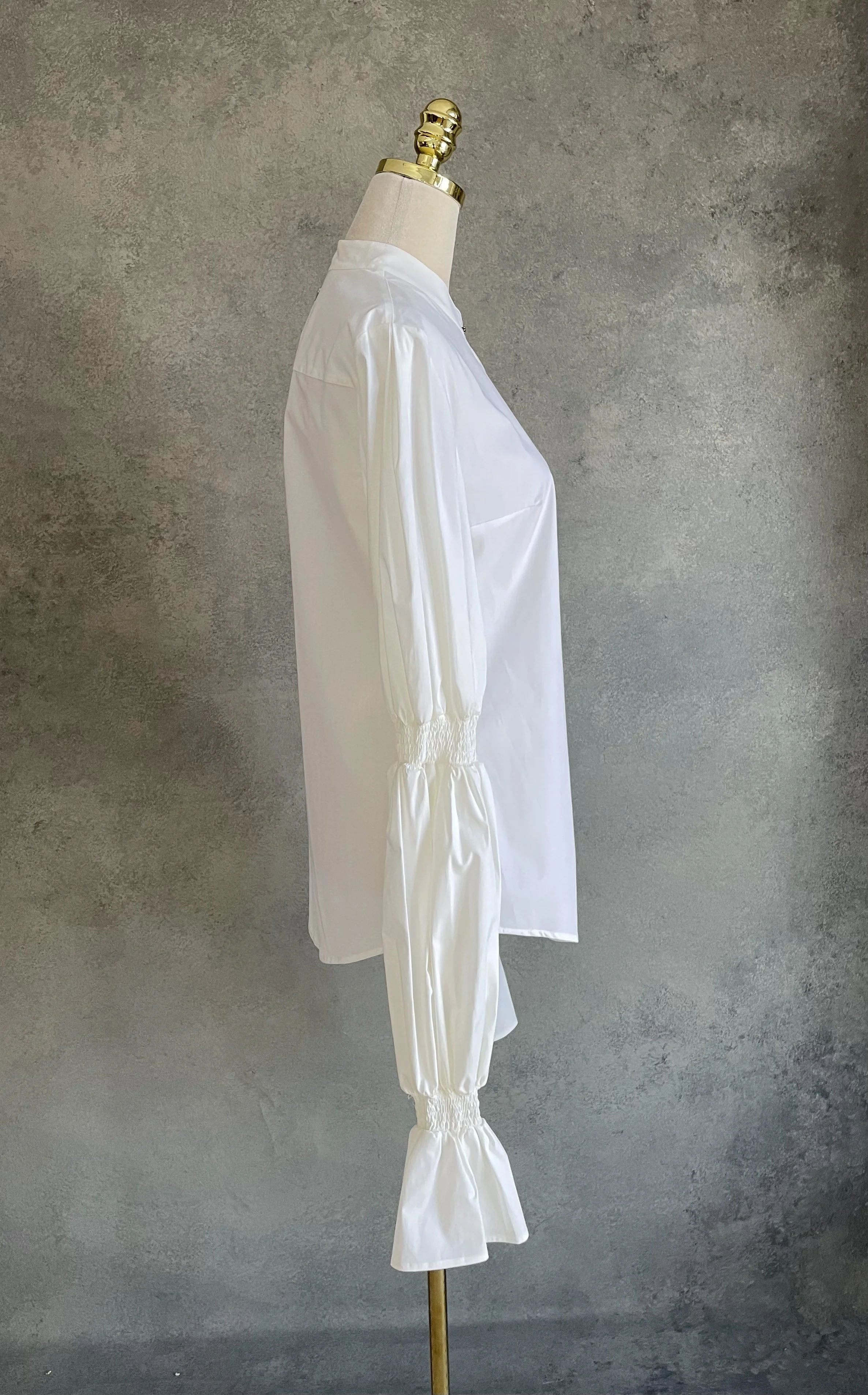 Side profile view of the white Dondup shirt on a mannequin, highlighting the long, sculptural sleeves.