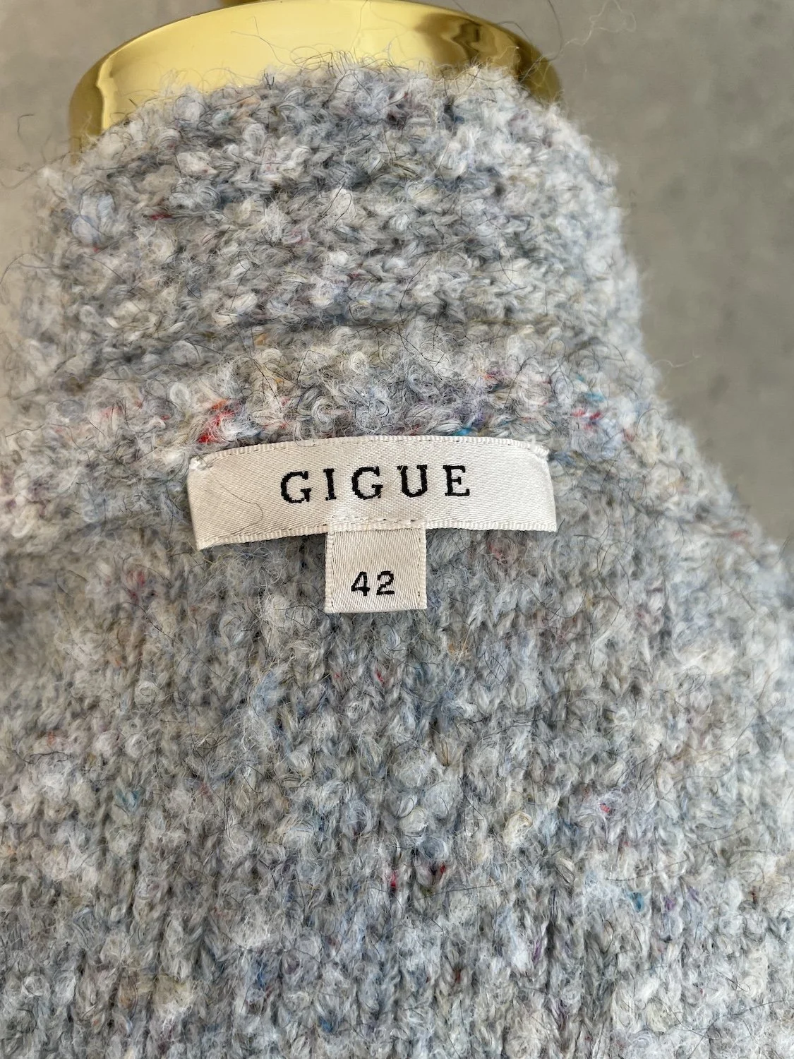 Detail shot of the interior Gigue brand label and size 42 tag sewn into the neckline.
