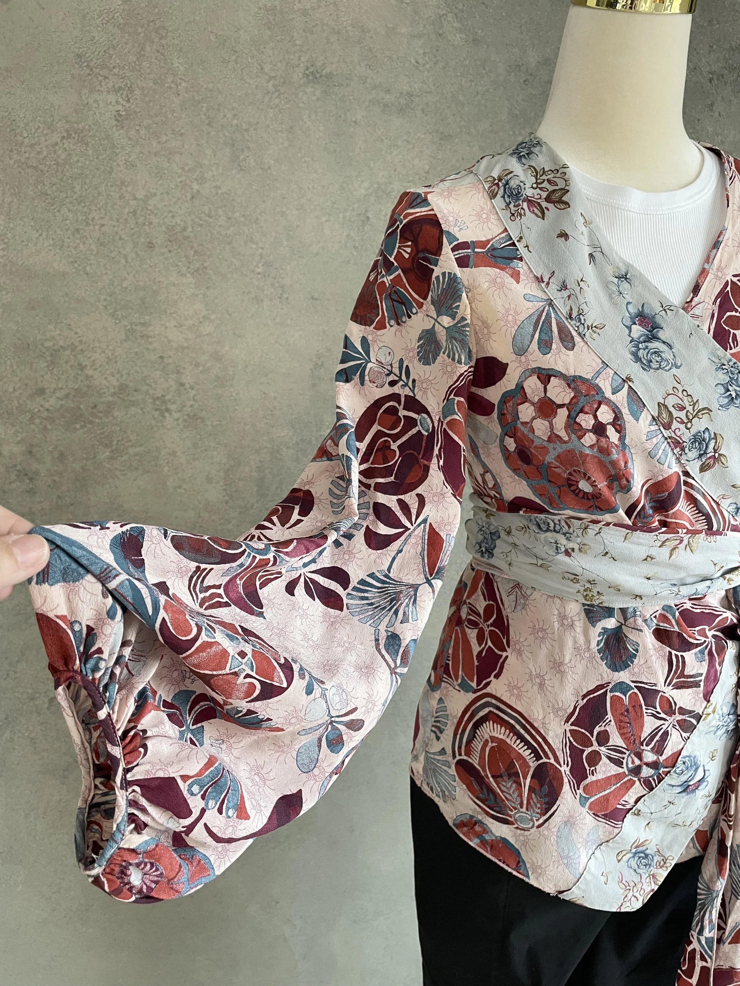 Close-up of the voluminous puff sleeve on the Dondup silk blouse, showing the gathered cuff and soft silk drape.