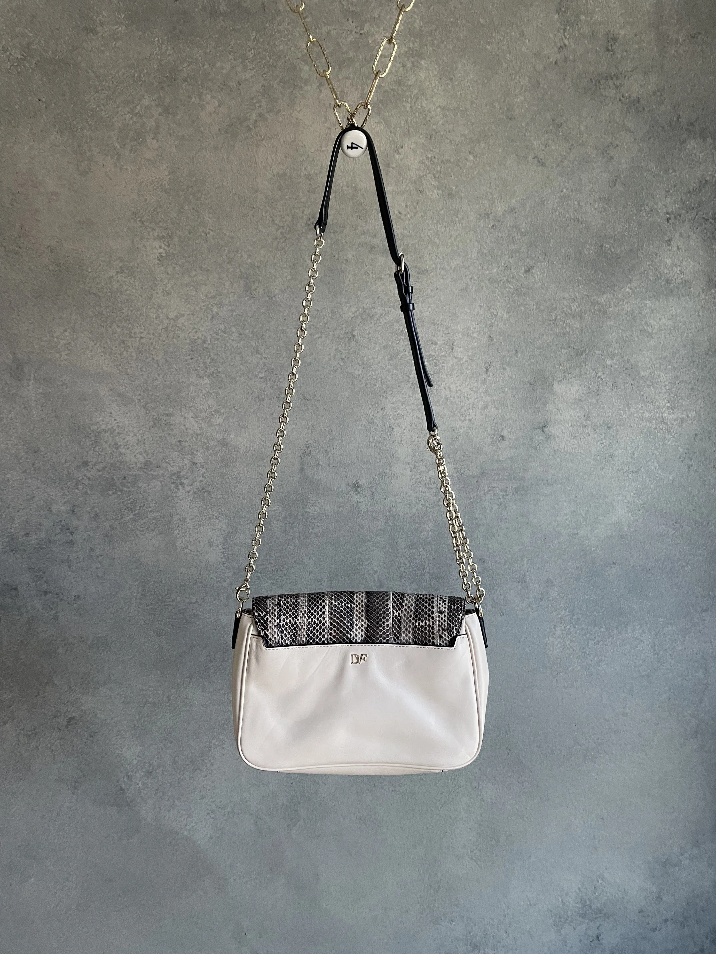 Front profile of the DVF 440 bag hanging, displaying its versatile size and classic envelope shape.
