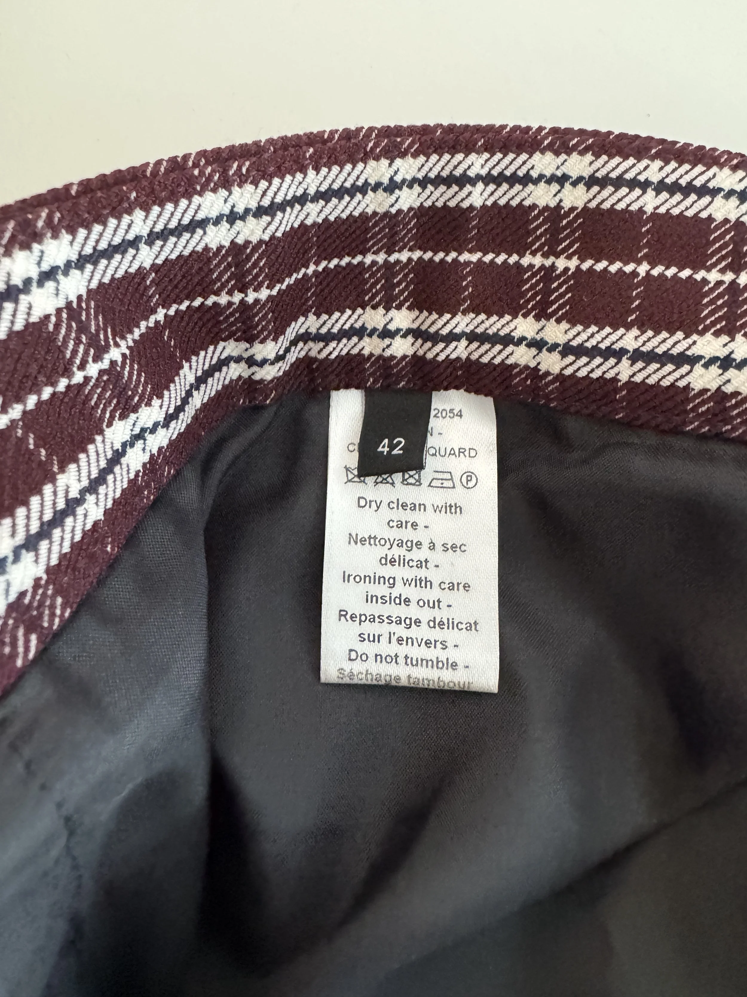 Close-up of the interior care label detailing dry cleaning instructions and a size '42' tag.