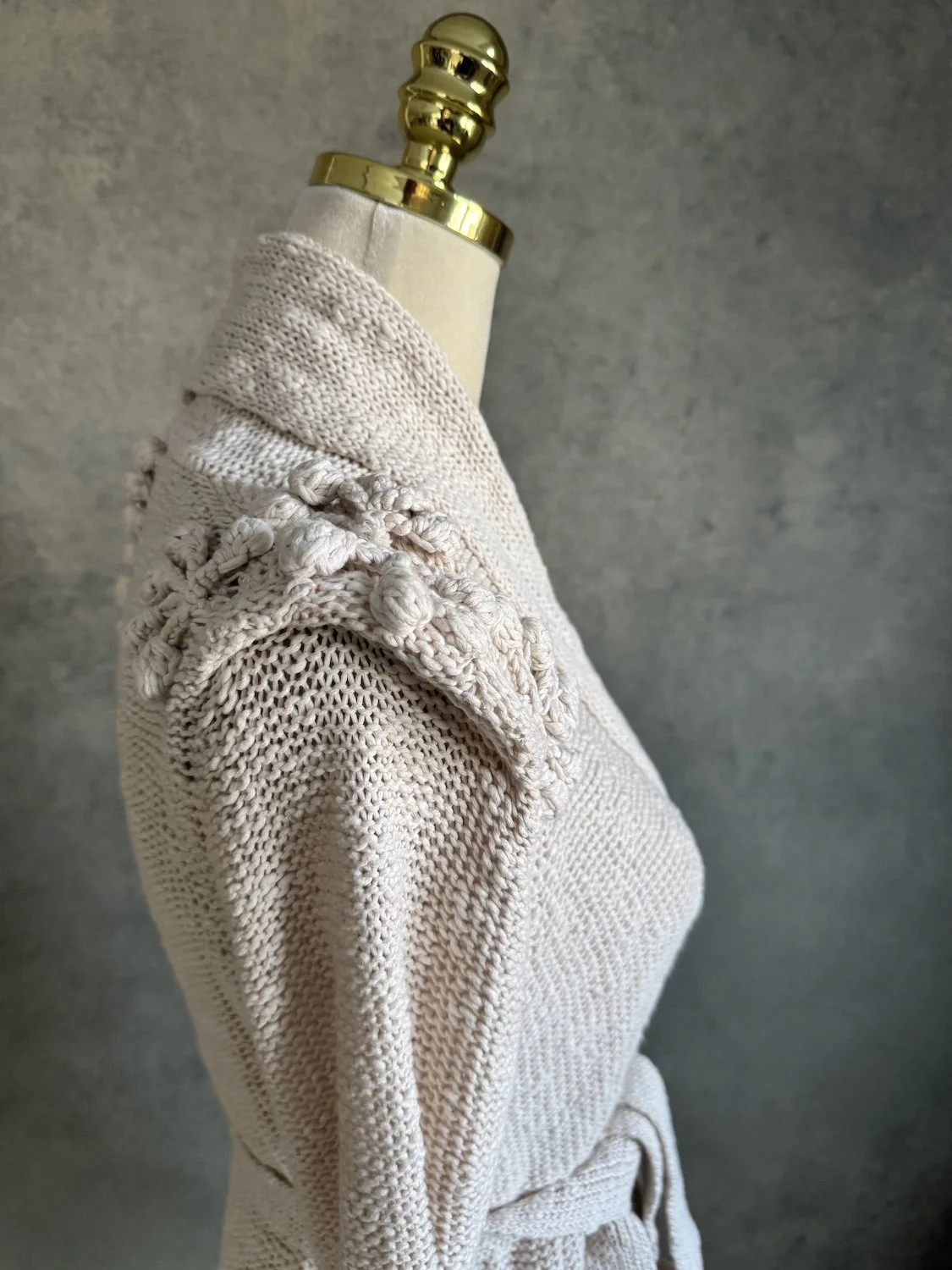 Close-up of intricate 3D bobble knit appliques on the shoulder of By Malene Birger cardigan