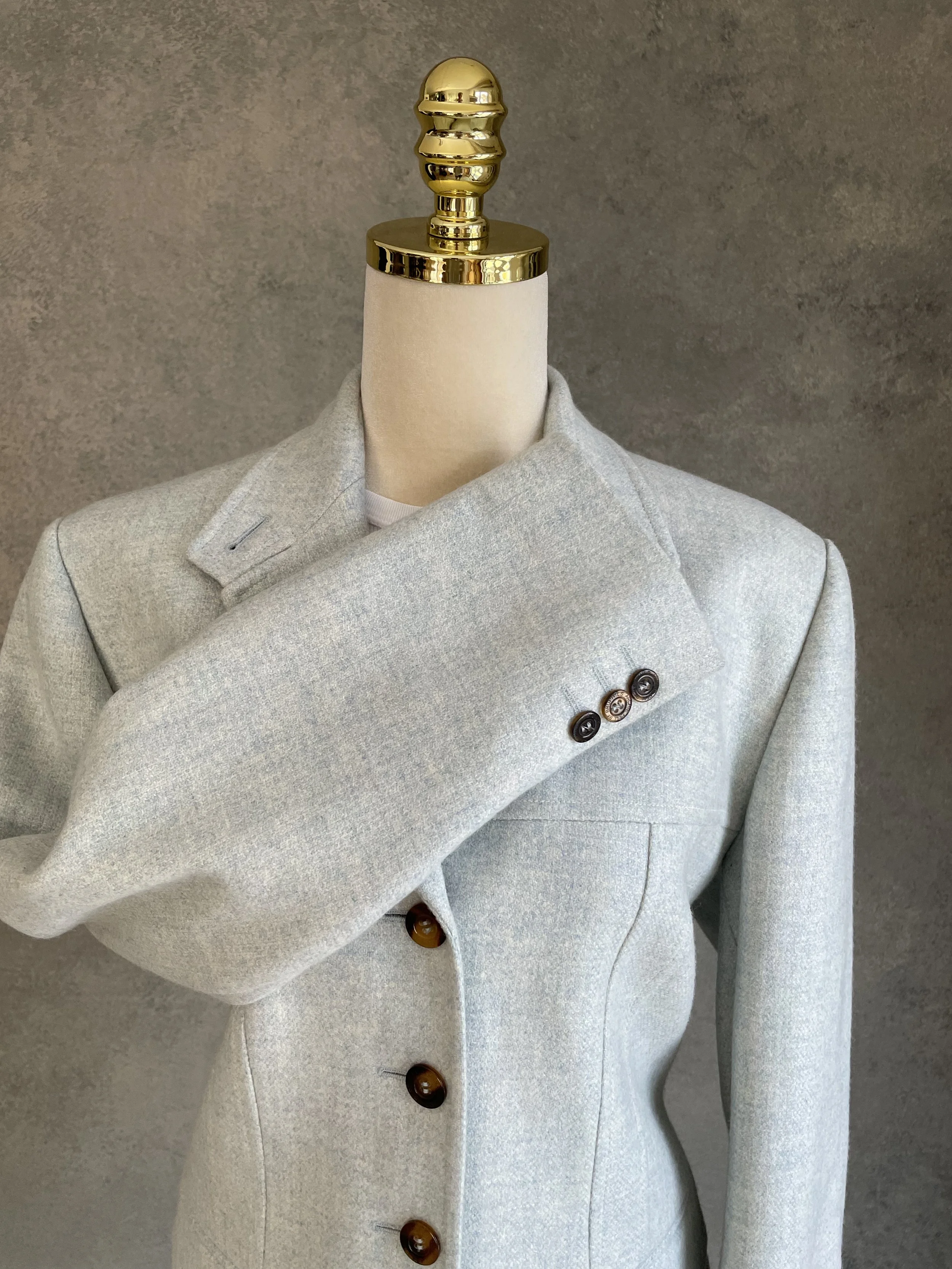 Detailed view of the blazer sleeve and decorative buttons at the cuff.