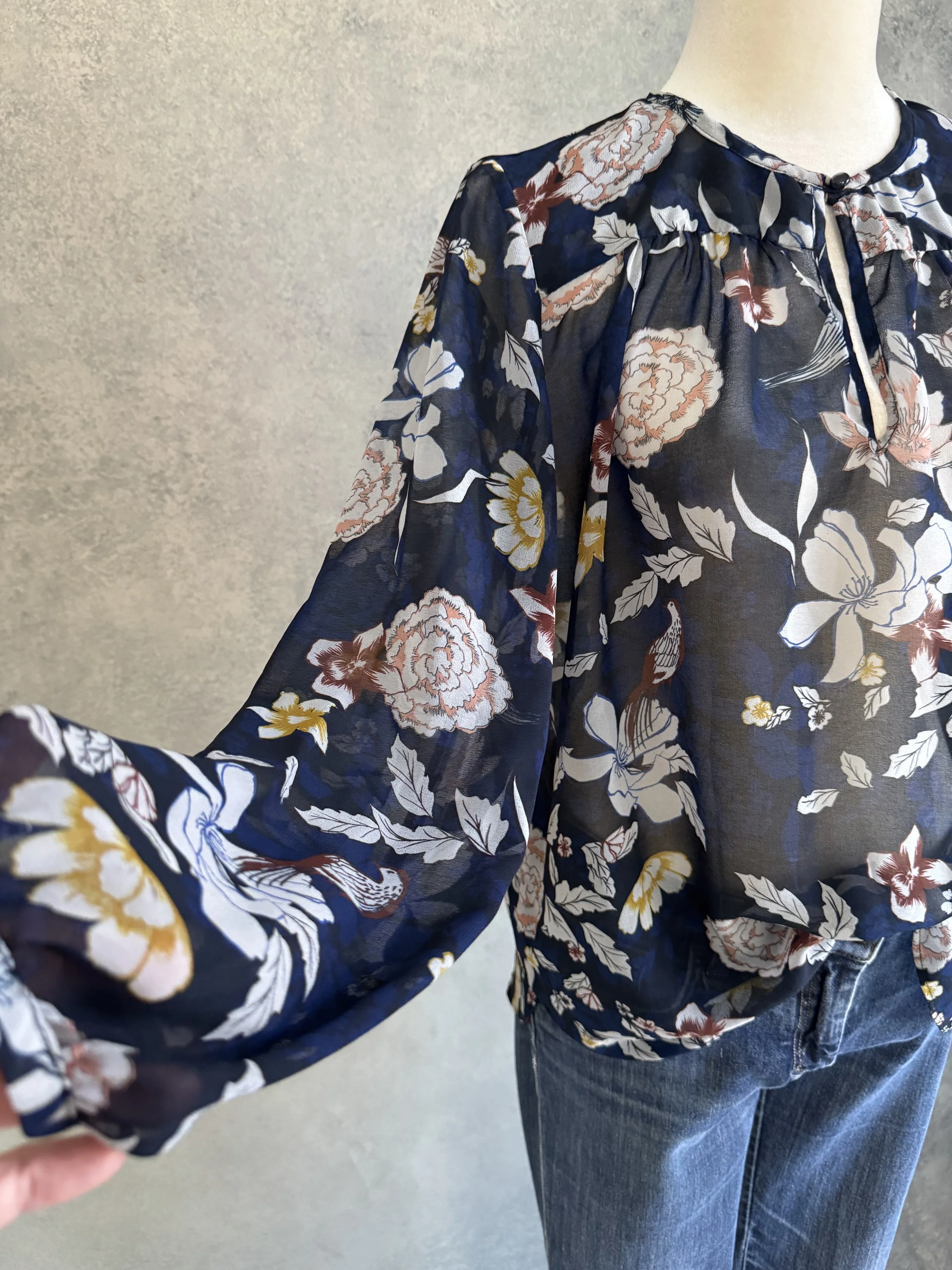 Close-up of the Gigue floral blouse cuff, highlighting the button detail and soft fabric drape