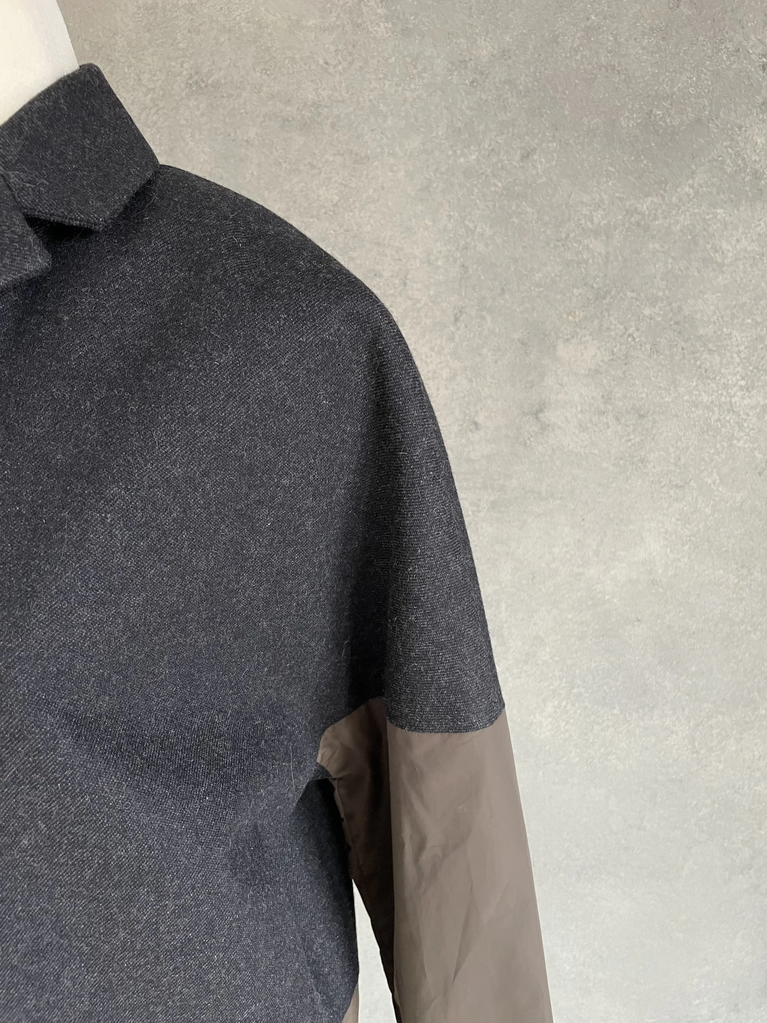 Detail view of the shoulder construction and sleeve transition on the Rue Blanche coat.