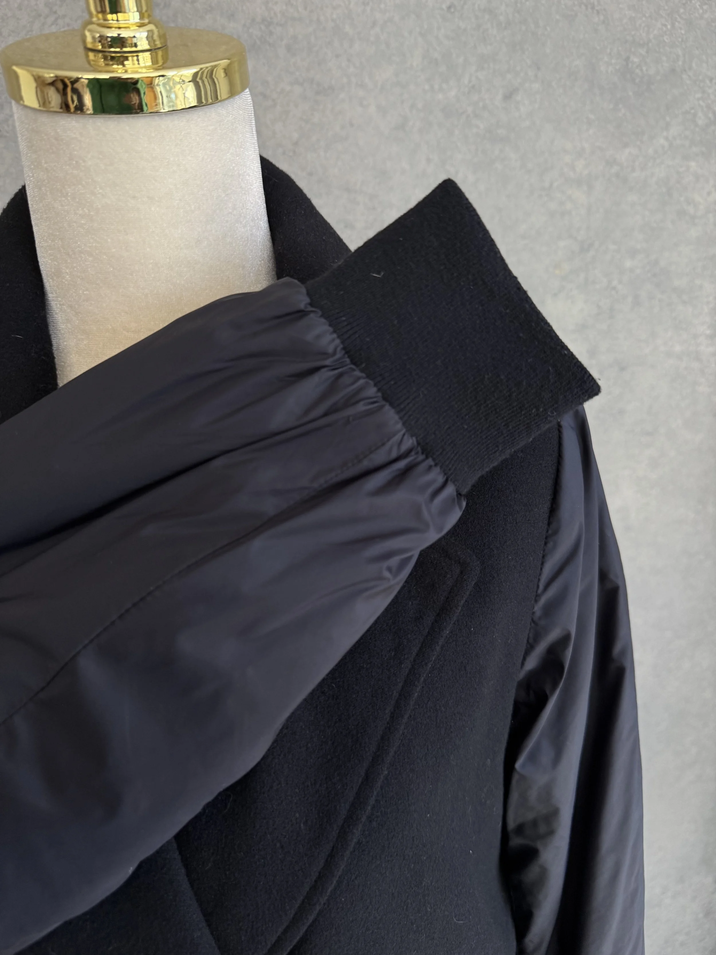 Close-up of the sleeve featuring glossy nylon fabric and an elastic ribbed cuff.