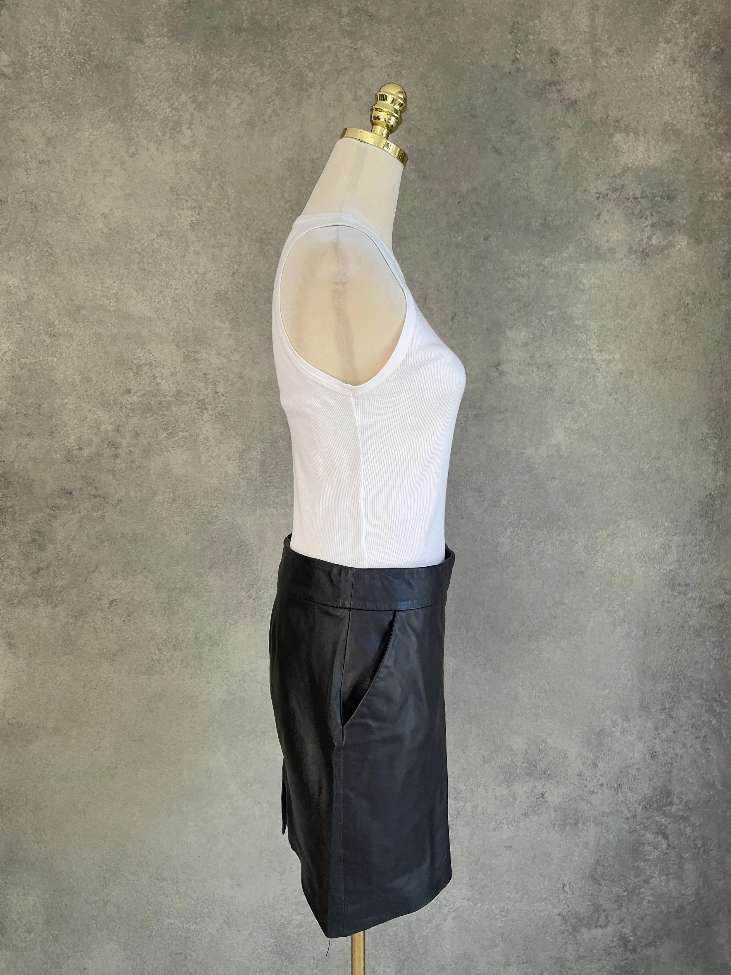 Side view of a black leather pencil skirt showing the functional side pocket.