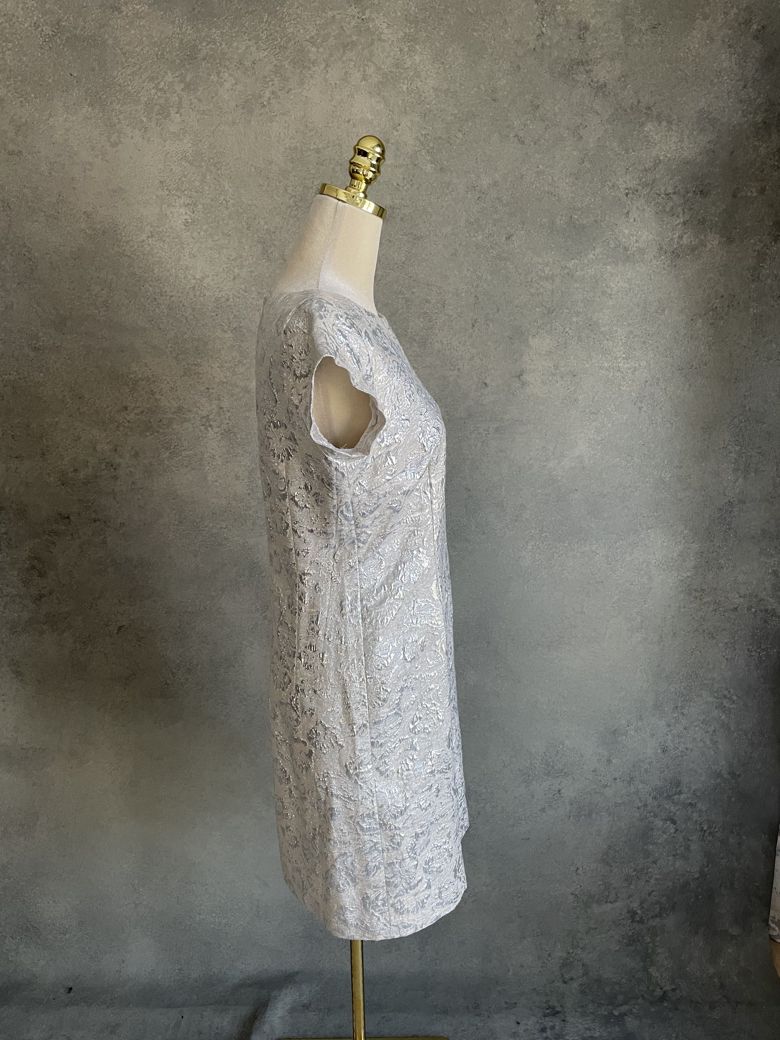 Side profile view of the silver short-sleeved Scapa dress on a mannequin.