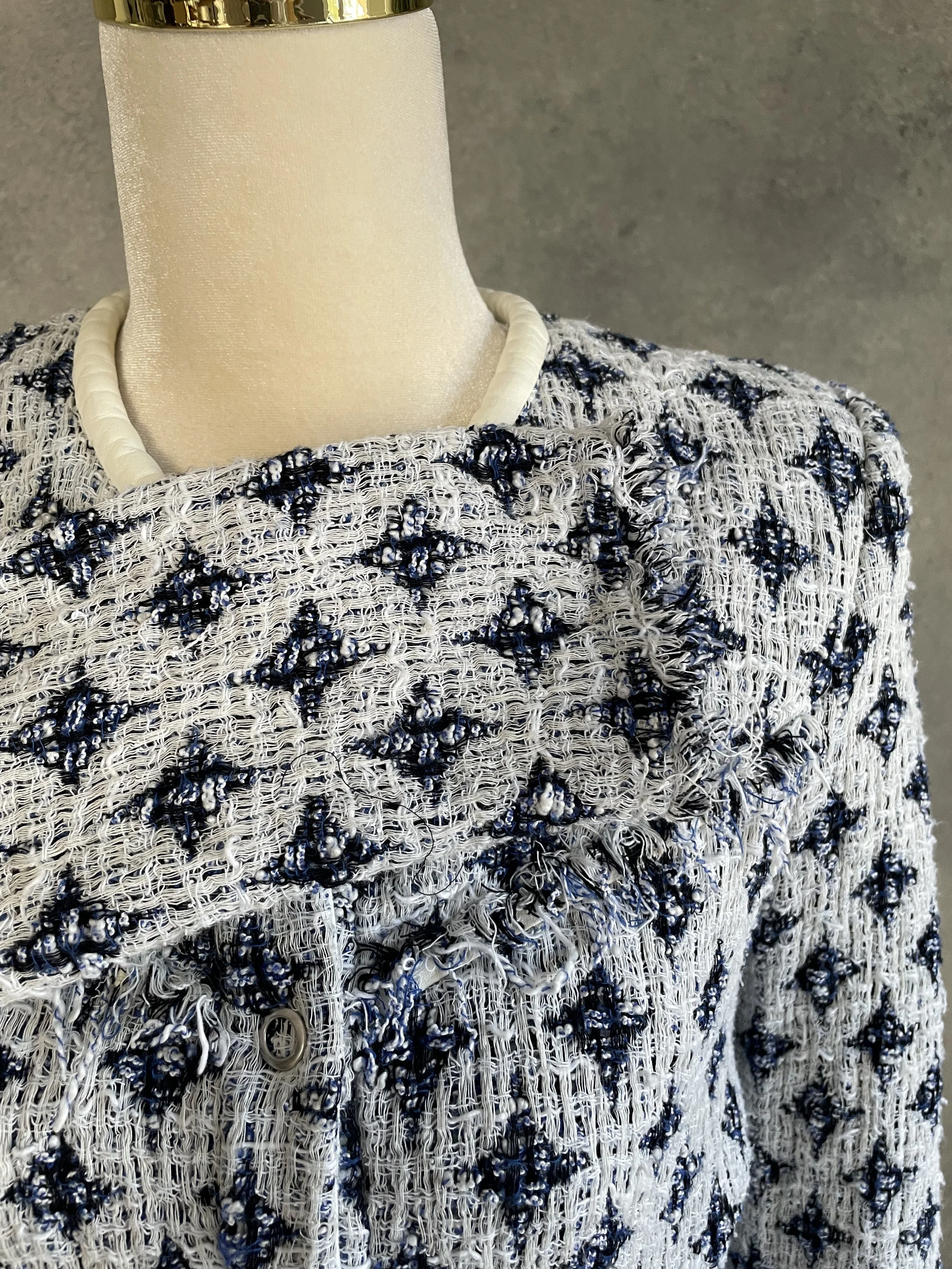 Close-up view of the front lapel and frayed tweed edge of the IRO jacket.