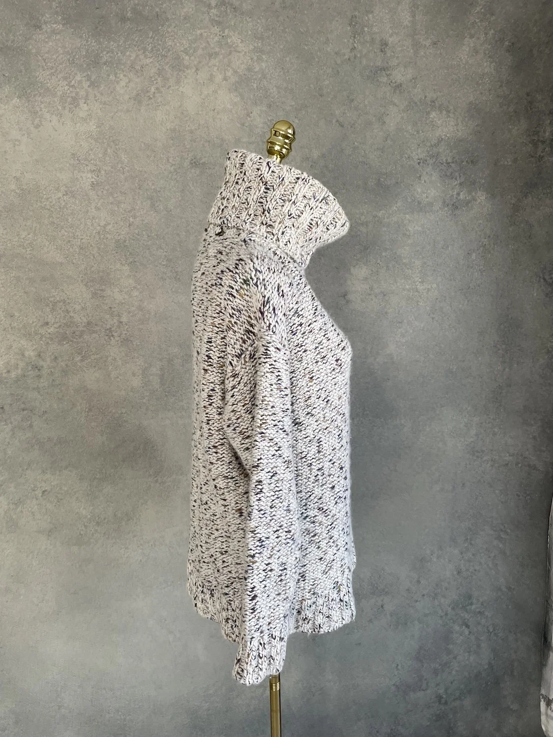 Side profile view of the Essentiel Antwerp chunky turtleneck sweater on a mannequin, showing the relaxed drop-shoulder silhouette and length.