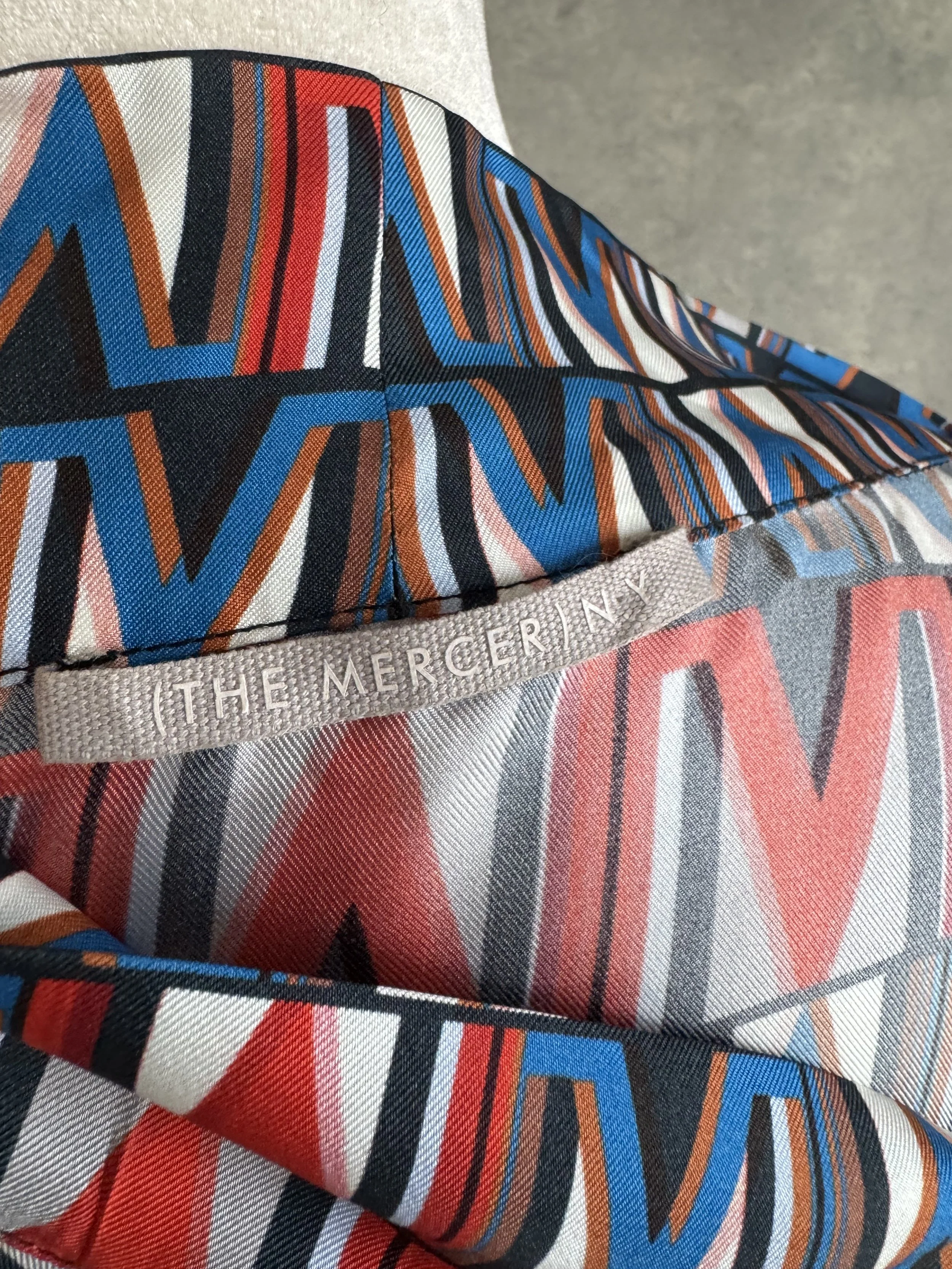 Close-up of the (THE MERCER) N.Y. fabric label and care instructions inside the silk blouse.