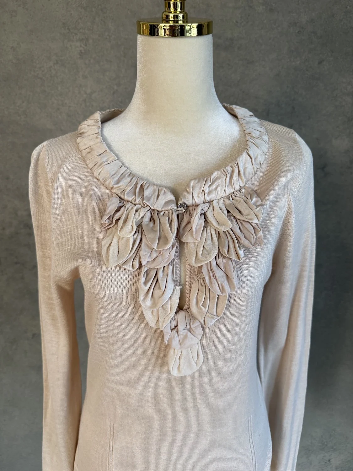 Close-up of GUSTAV beige cotton top featuring artistic ruffled silk petal trim around the collar