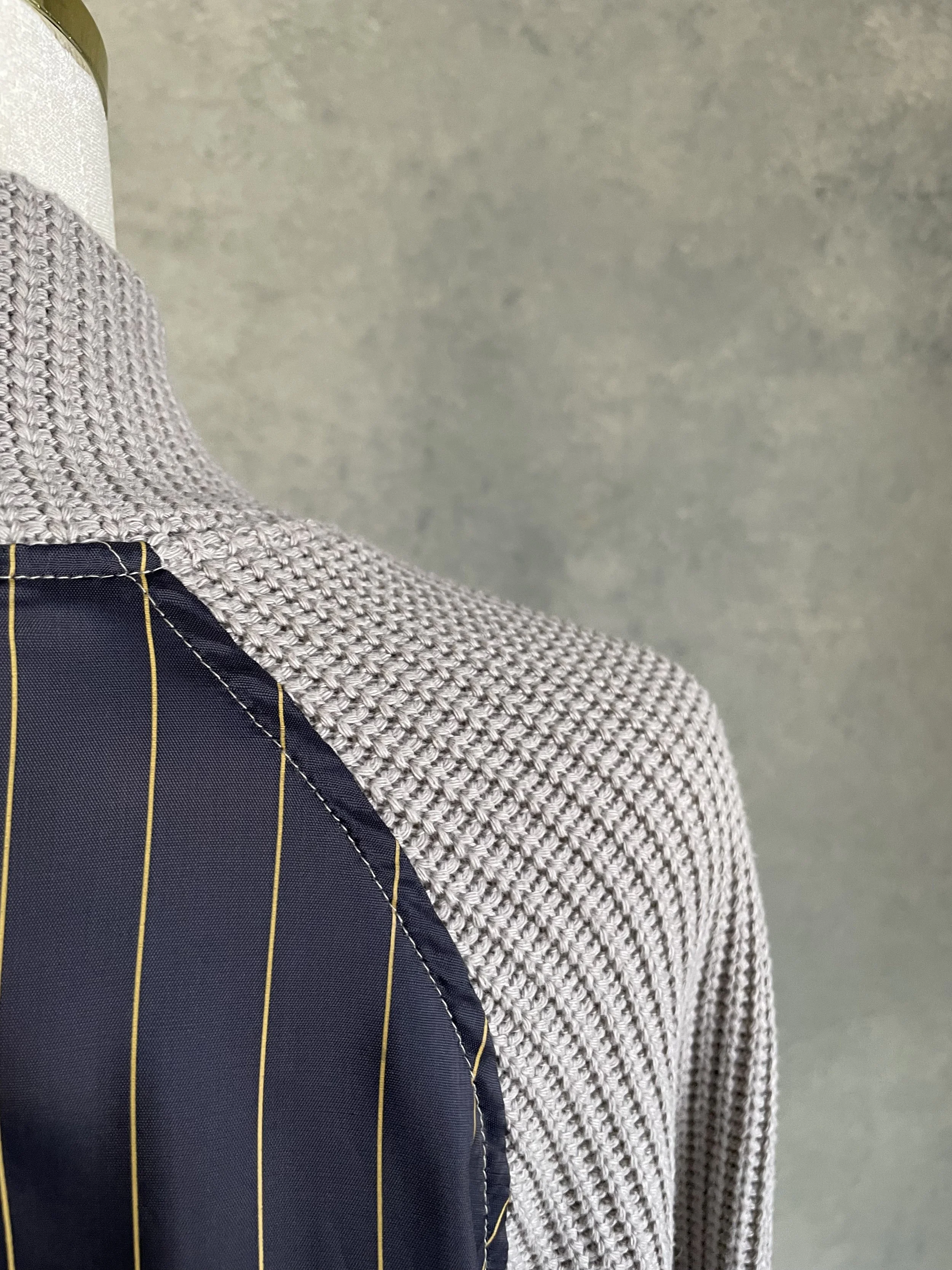 Close-up of the shoulder seam construction showing the integration of knit panels on the Vladimir Karaleev sweater.