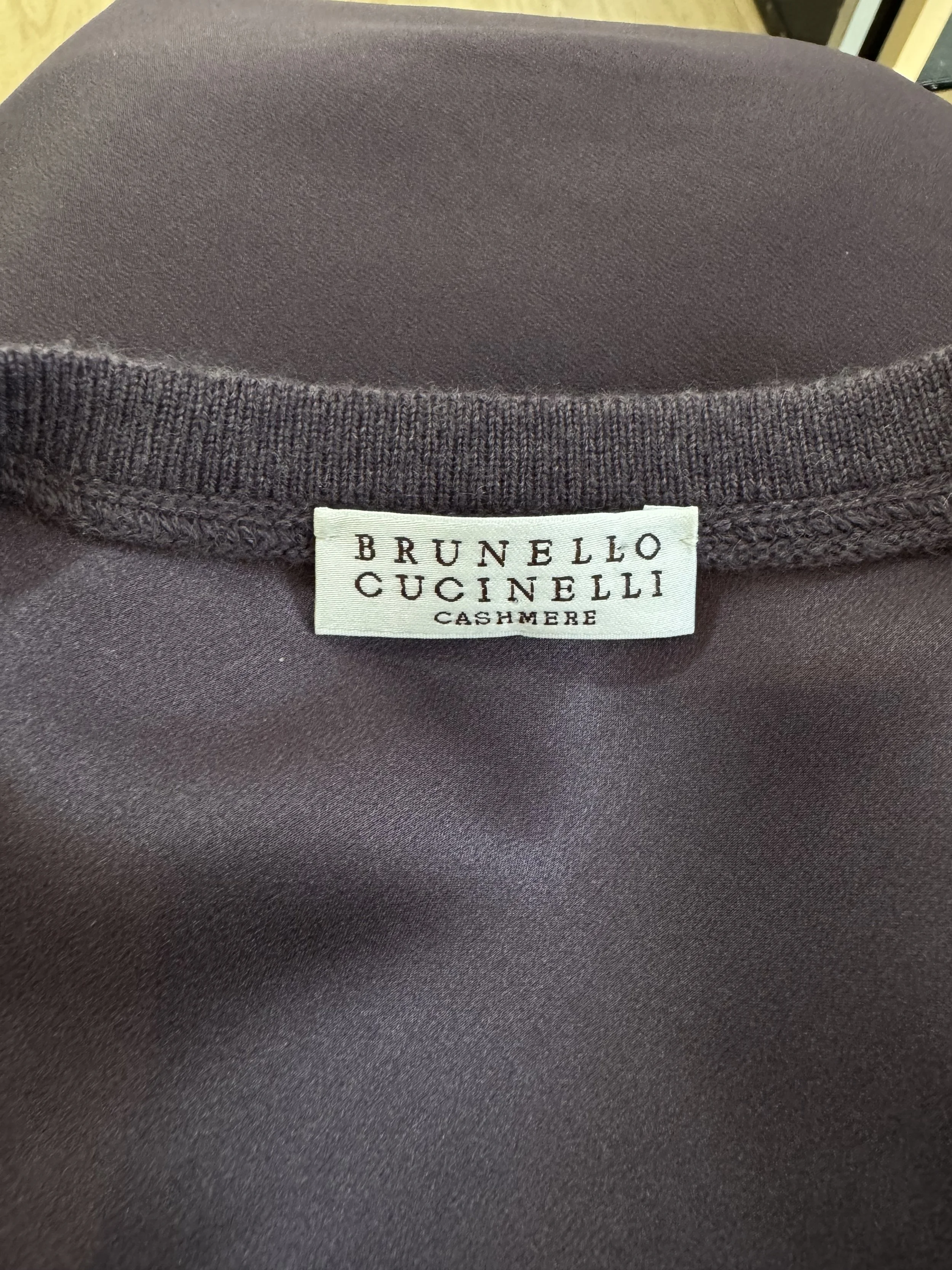 Detail of the iconic Brunello Cucinelli brand label, confirming its premium status and Italian luxury craftsmanship.