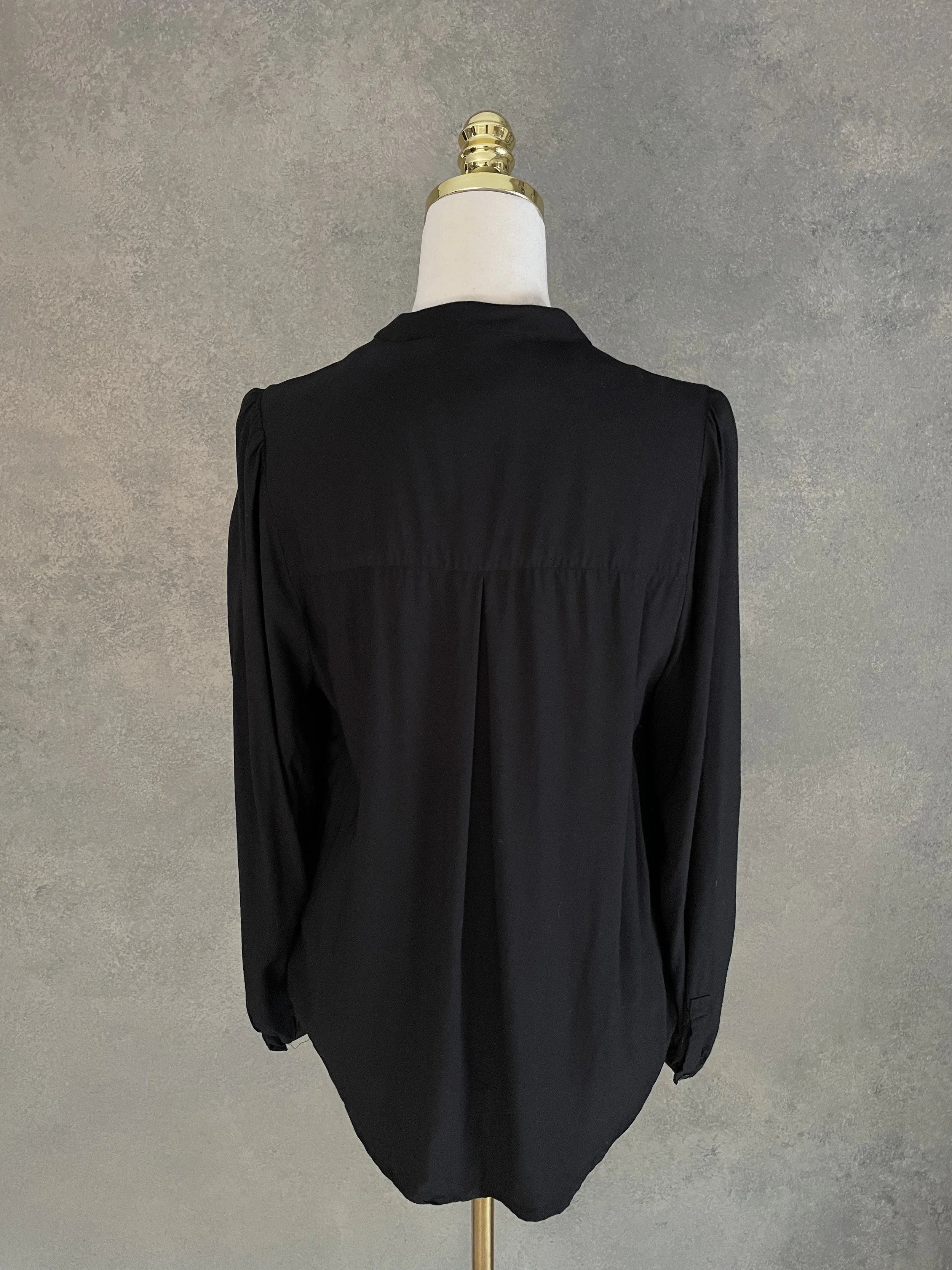 Rear view of the Rodebjer Lucy blouse featuring a central back pleat for a graceful drape.