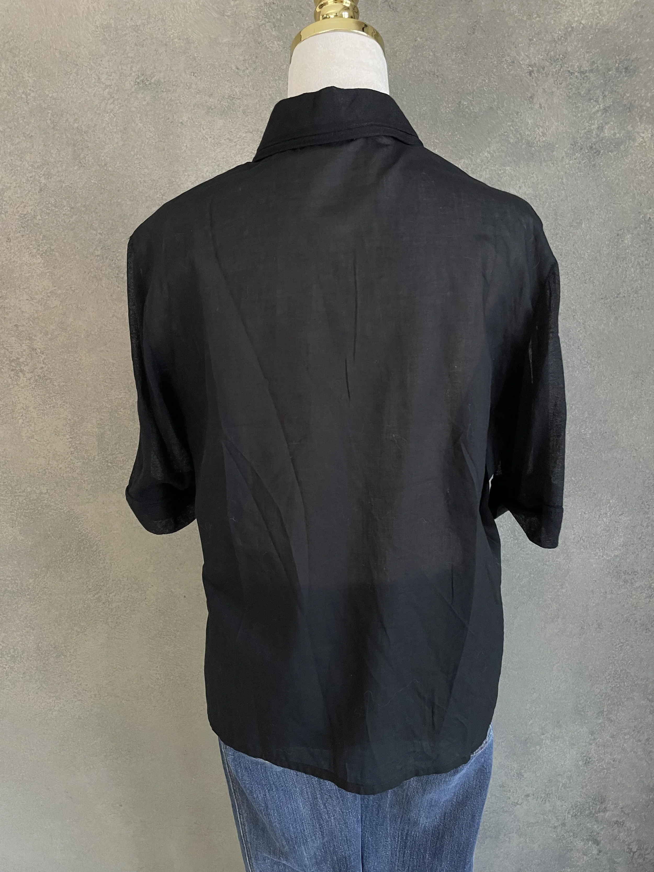 Full back view of the Kathleen Madden black blouse, emphasizing the smooth fabric and consistent silhouette