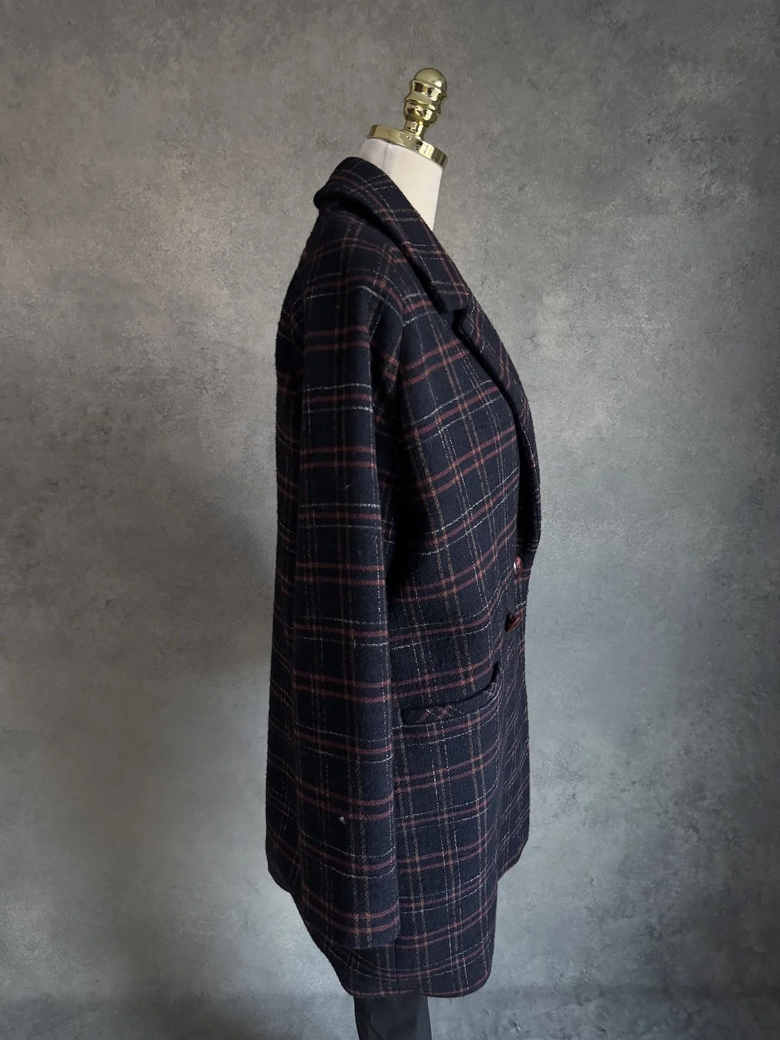 Side profile of the oversized coat on a mannequin.