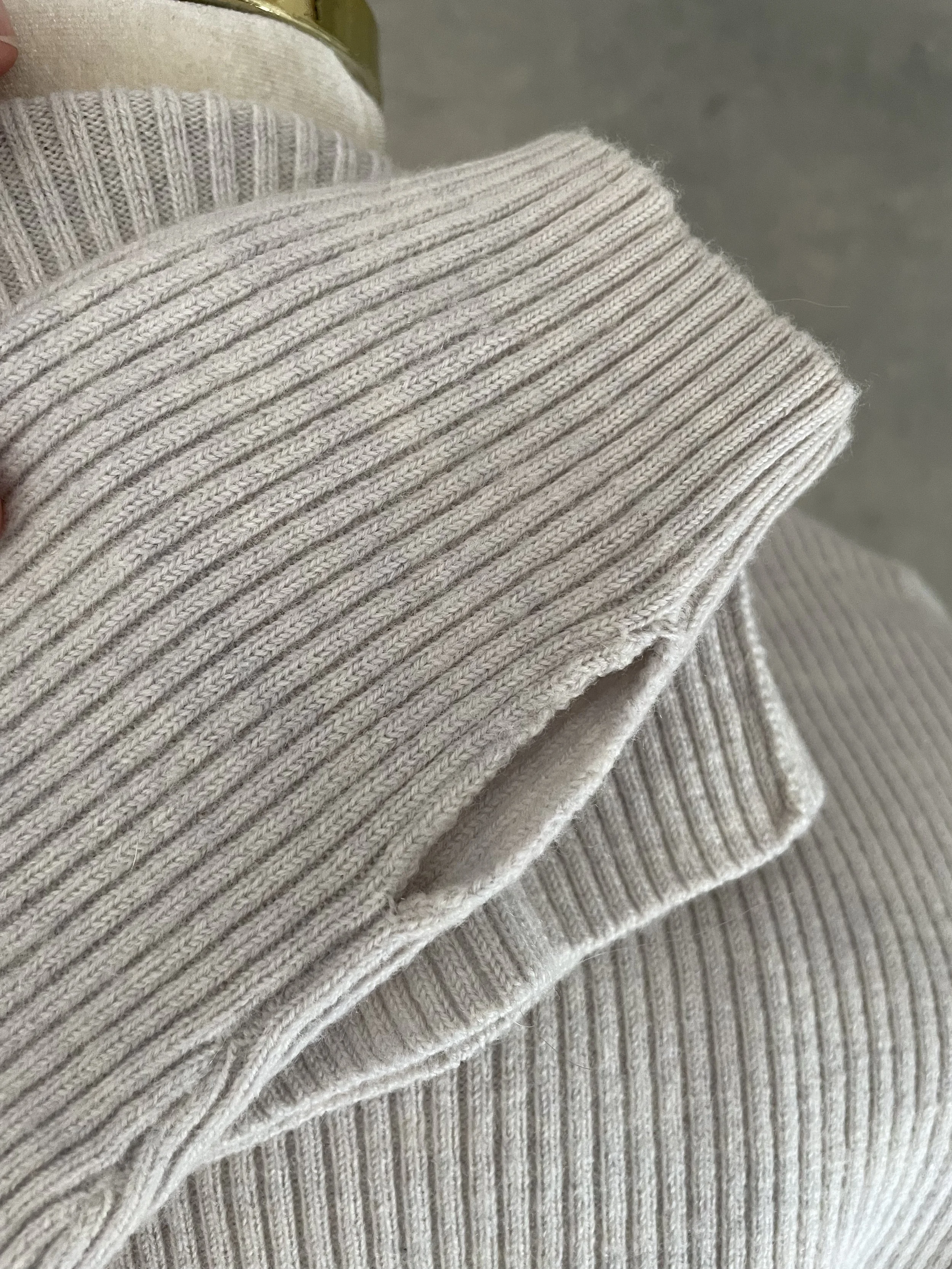 Close-up of the ribbed hem detail on the Rodebjer grey jumper, illustrating the garment's quality and texture.