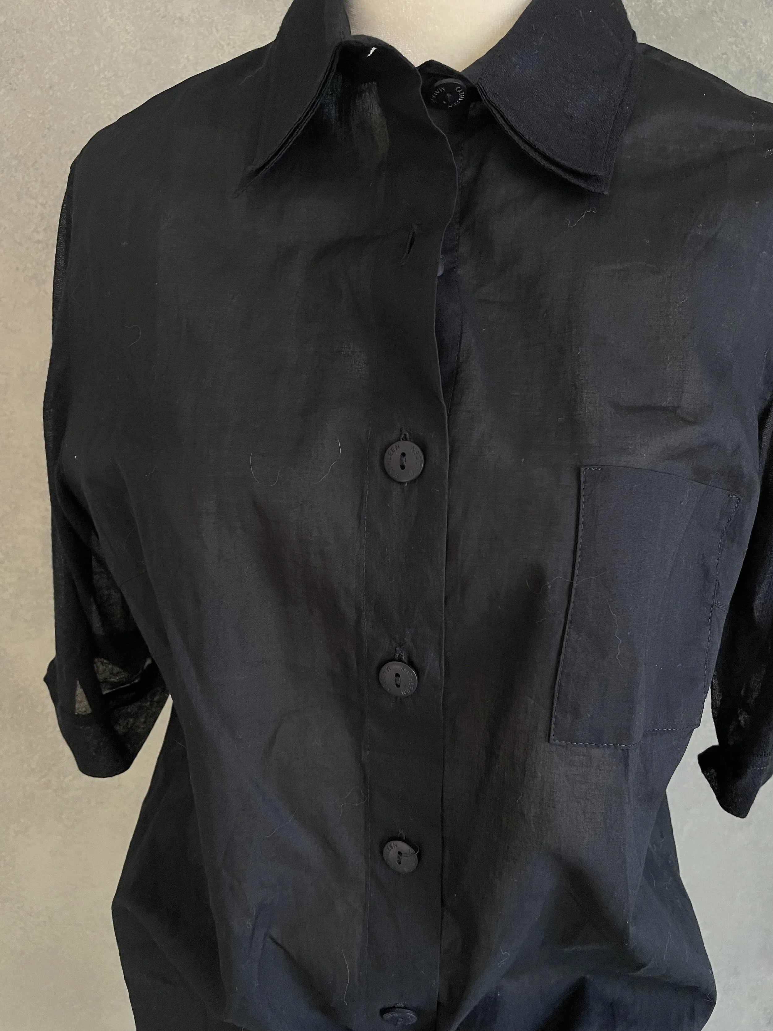Macro shot of the Kathleen Madden black blouse fabric, showing the fine, smooth texture and high-quality material finish