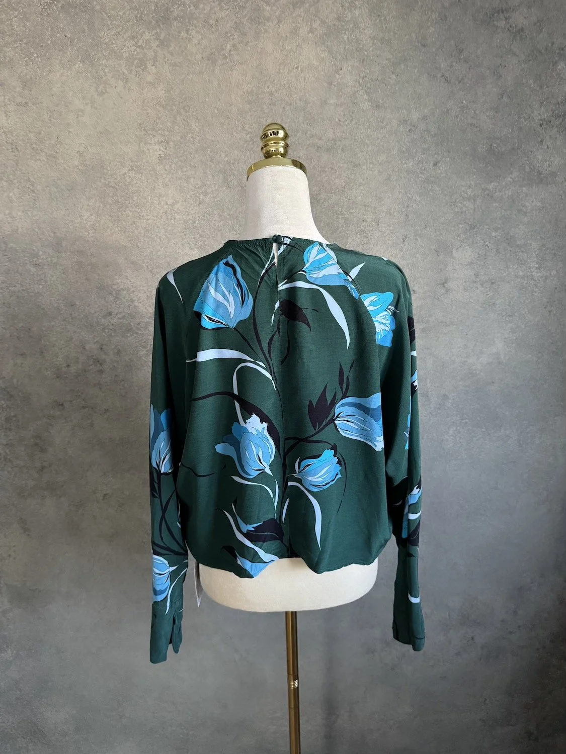 Back view of Gestuz emerald green floral blouse showing keyhole neck button closure