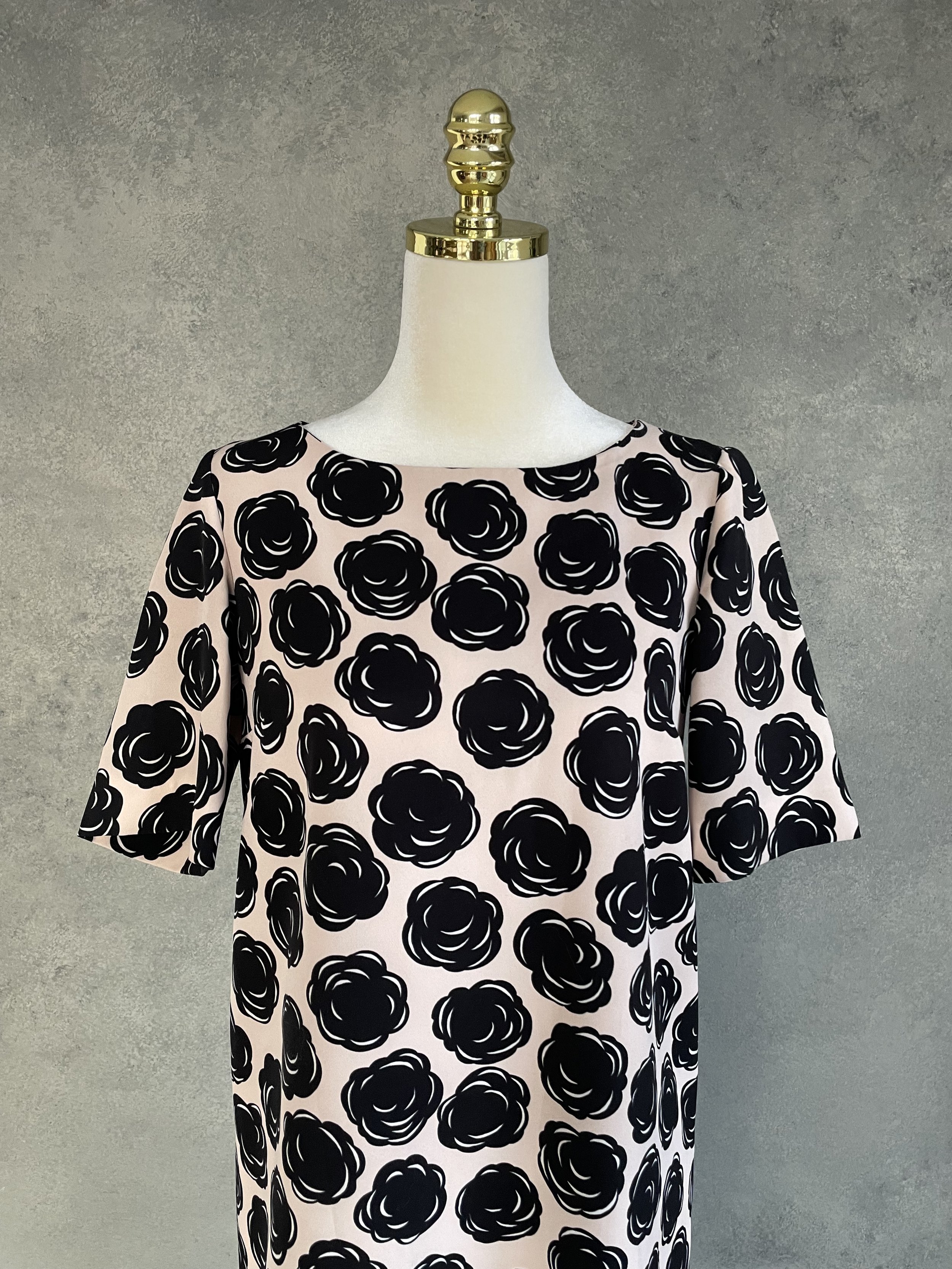Detail view of the Gigue floral dress neckline and shoulder fit, showcasing the clean tailoring and premium construction of the Belgian designer piece