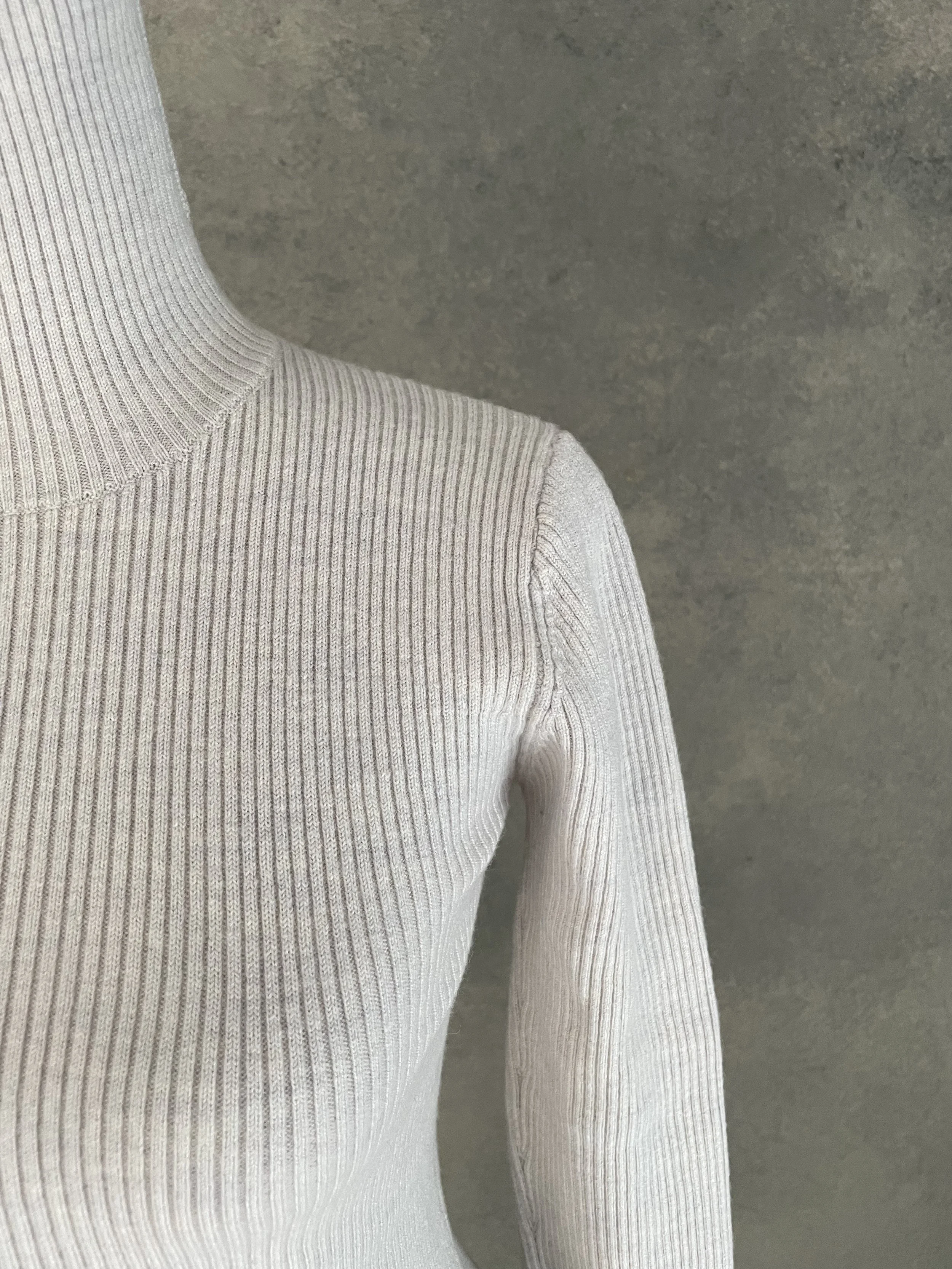 Close-up shot of the shoulder and arm construction of the Rodebjer grey ribbed knit top.