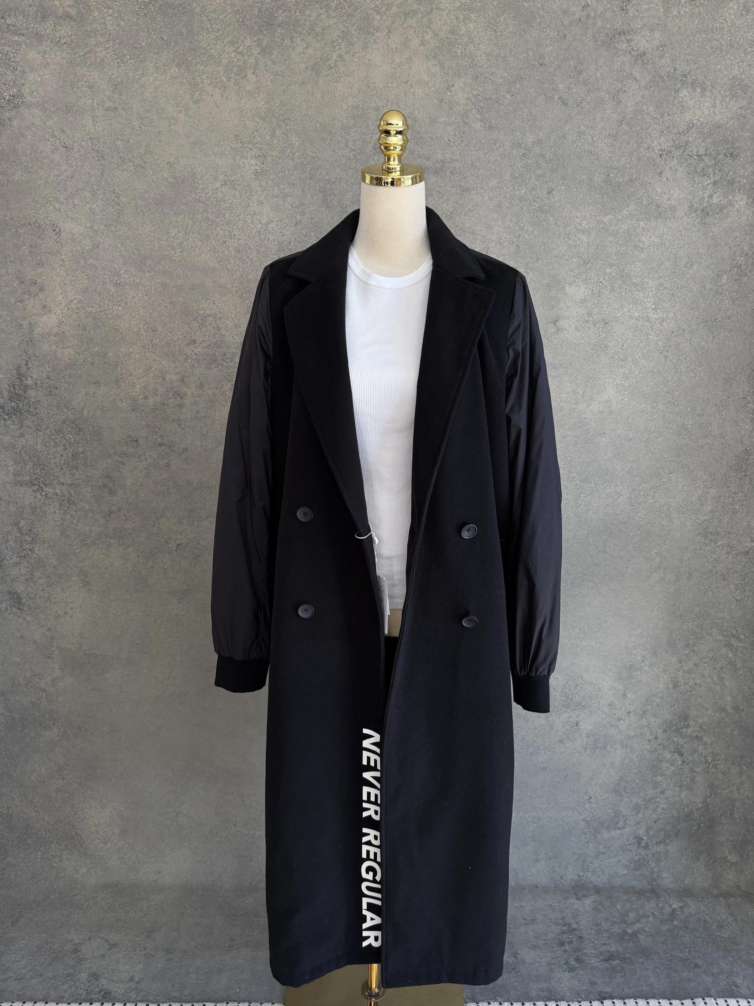 Alternative front view of the open coat layered over a white top.