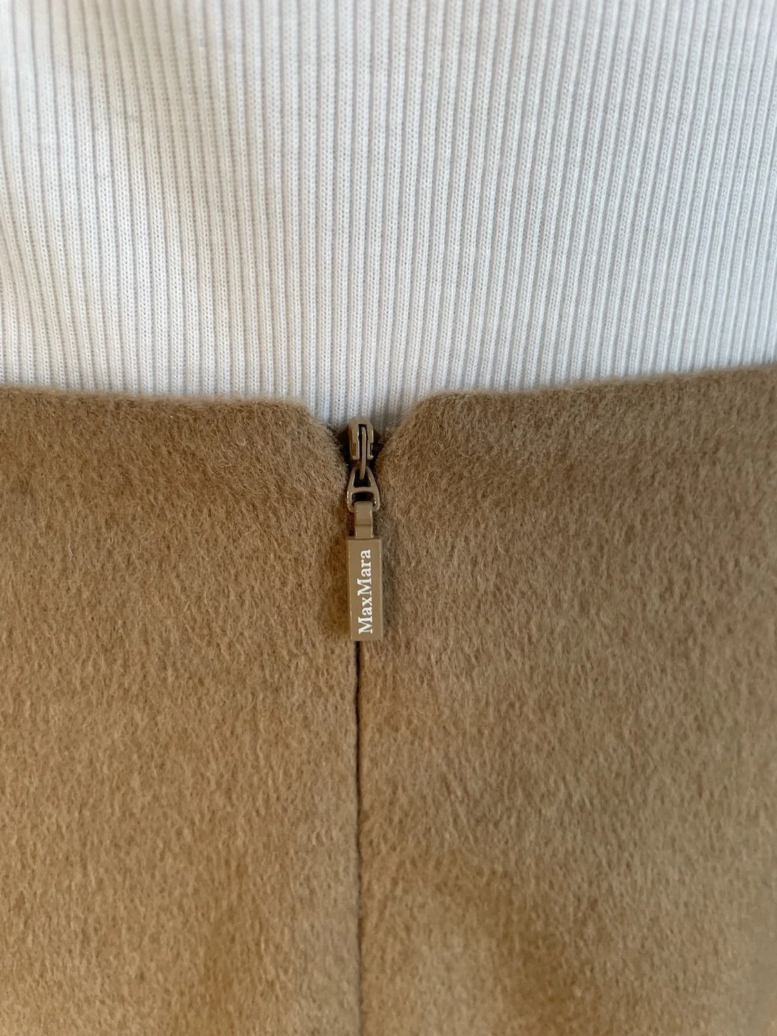 Max Mara branded gold-tone rear zipper pull detail on camel skirt