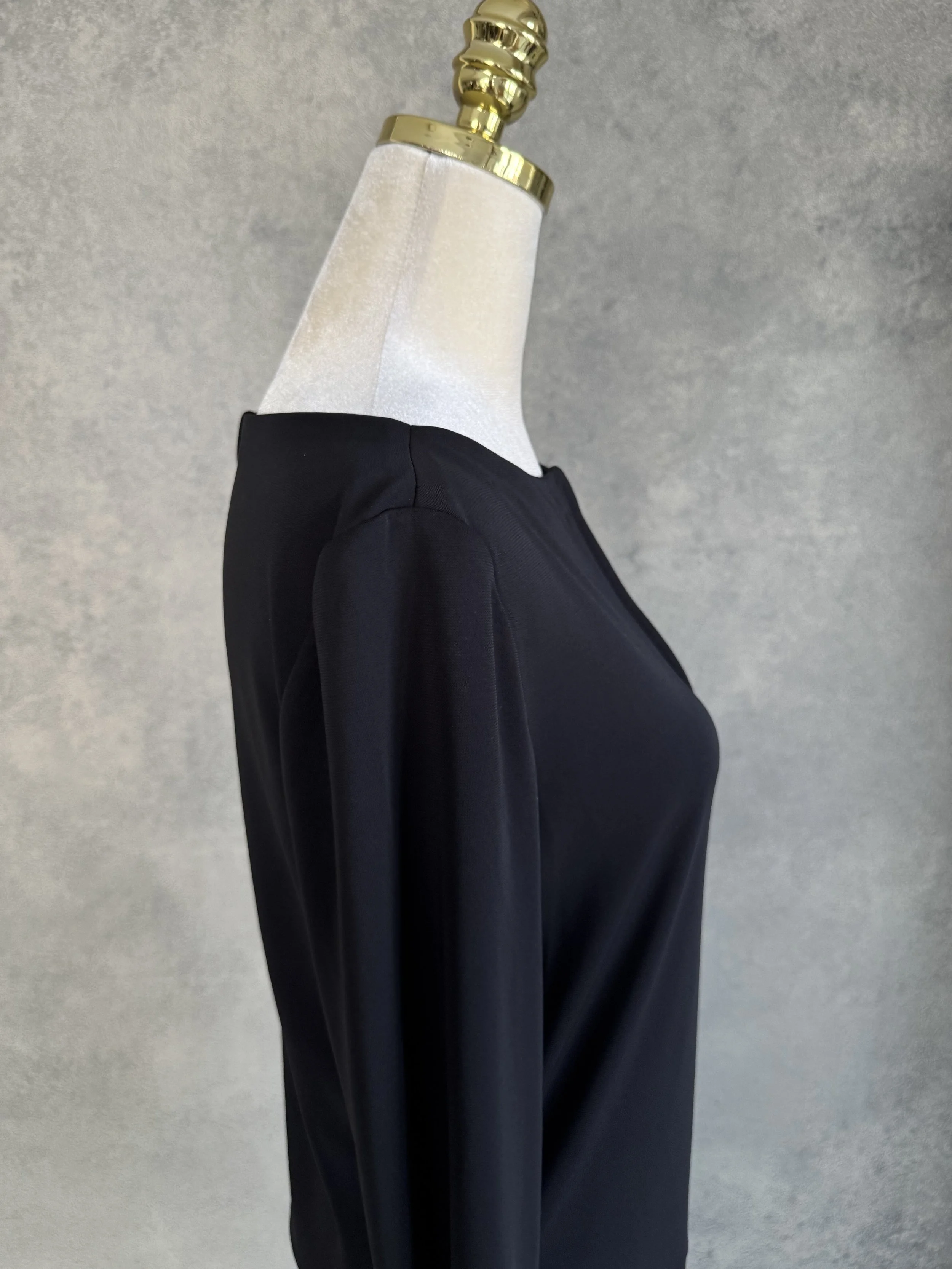 Close-up side profile view focusing on the shoulder and long sleeve construction of the black Filippa K dress.