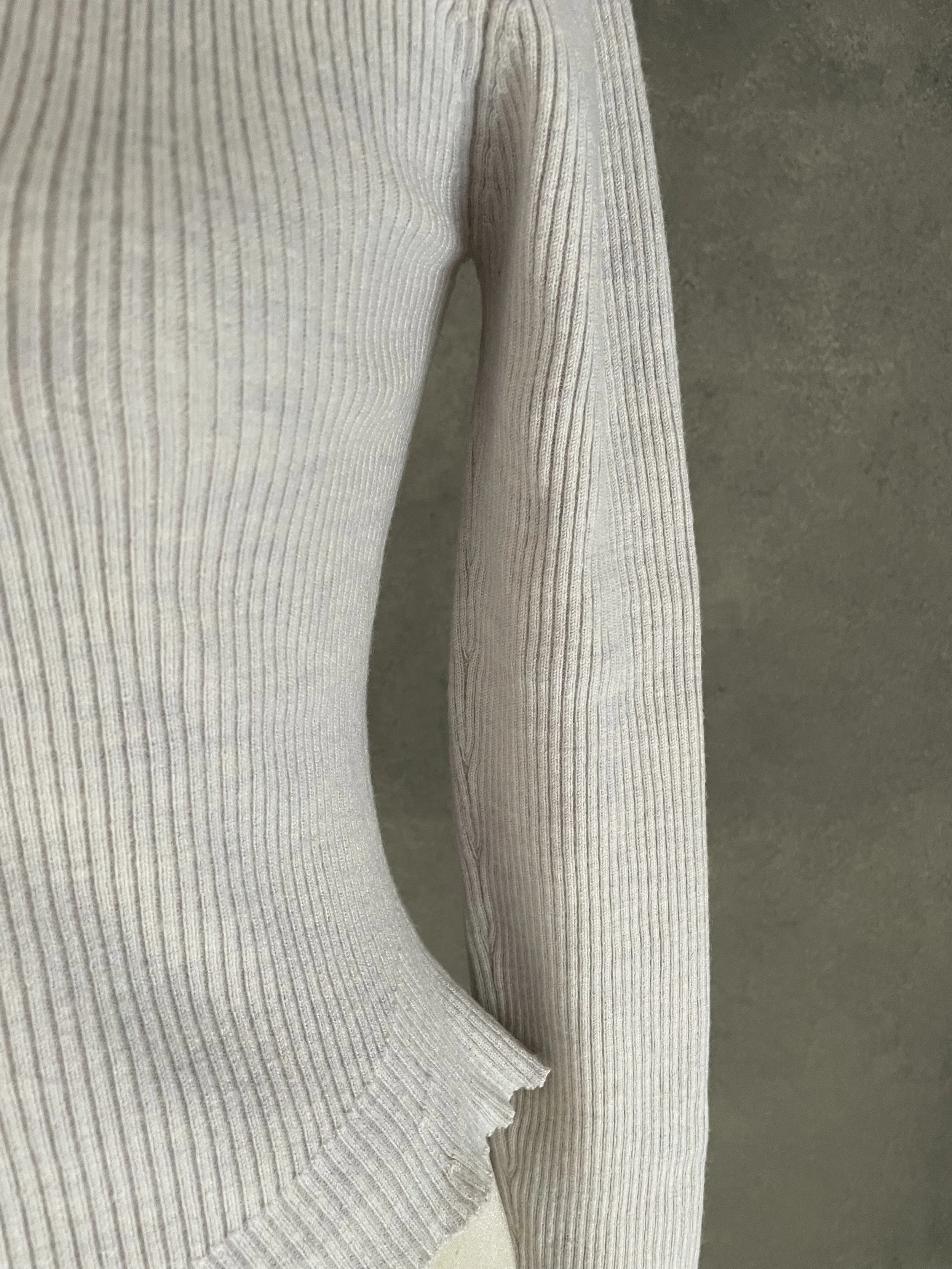 Close-up of the sleeve cuff on the Rodebjer grey ribbed jumper, showing the refined ribbed finish.