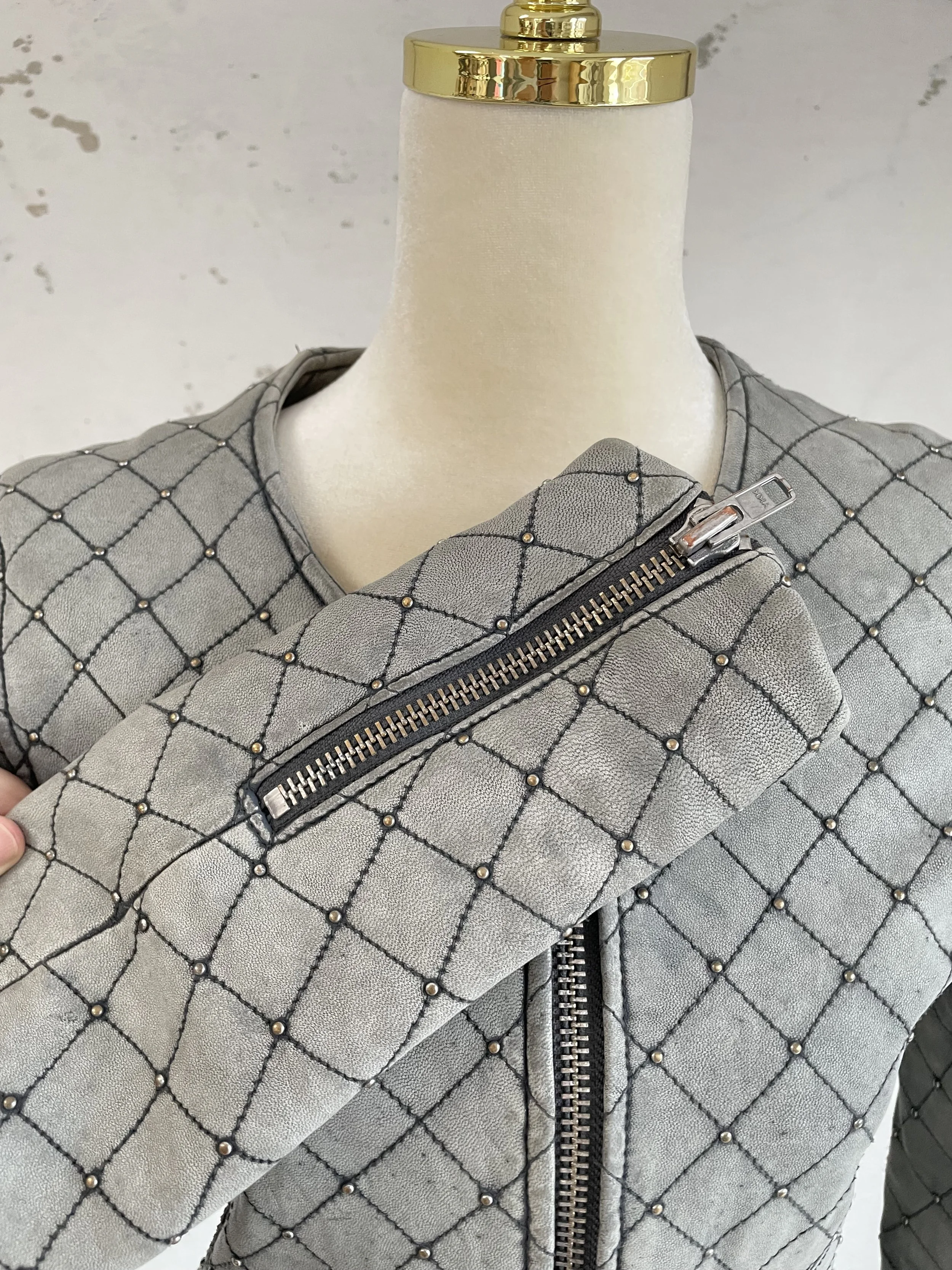 "Close-up detail of Iro jacket silver zippered pocket and sleeve cuff, showing premium hardware and leather texture