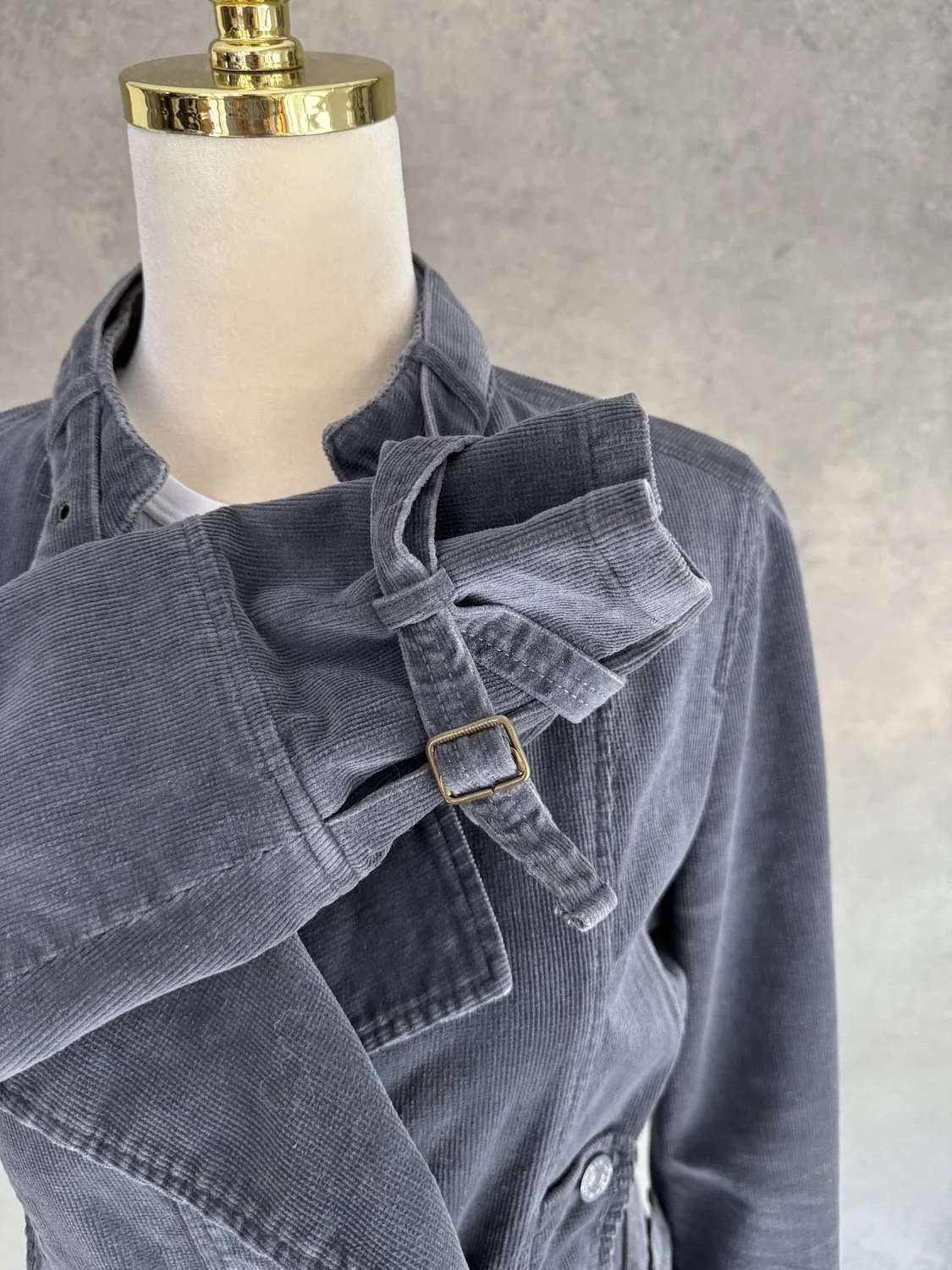 Close-up of the adjustable strap and buckle detail on the sleeve cuff of the corduroy biker jacket.