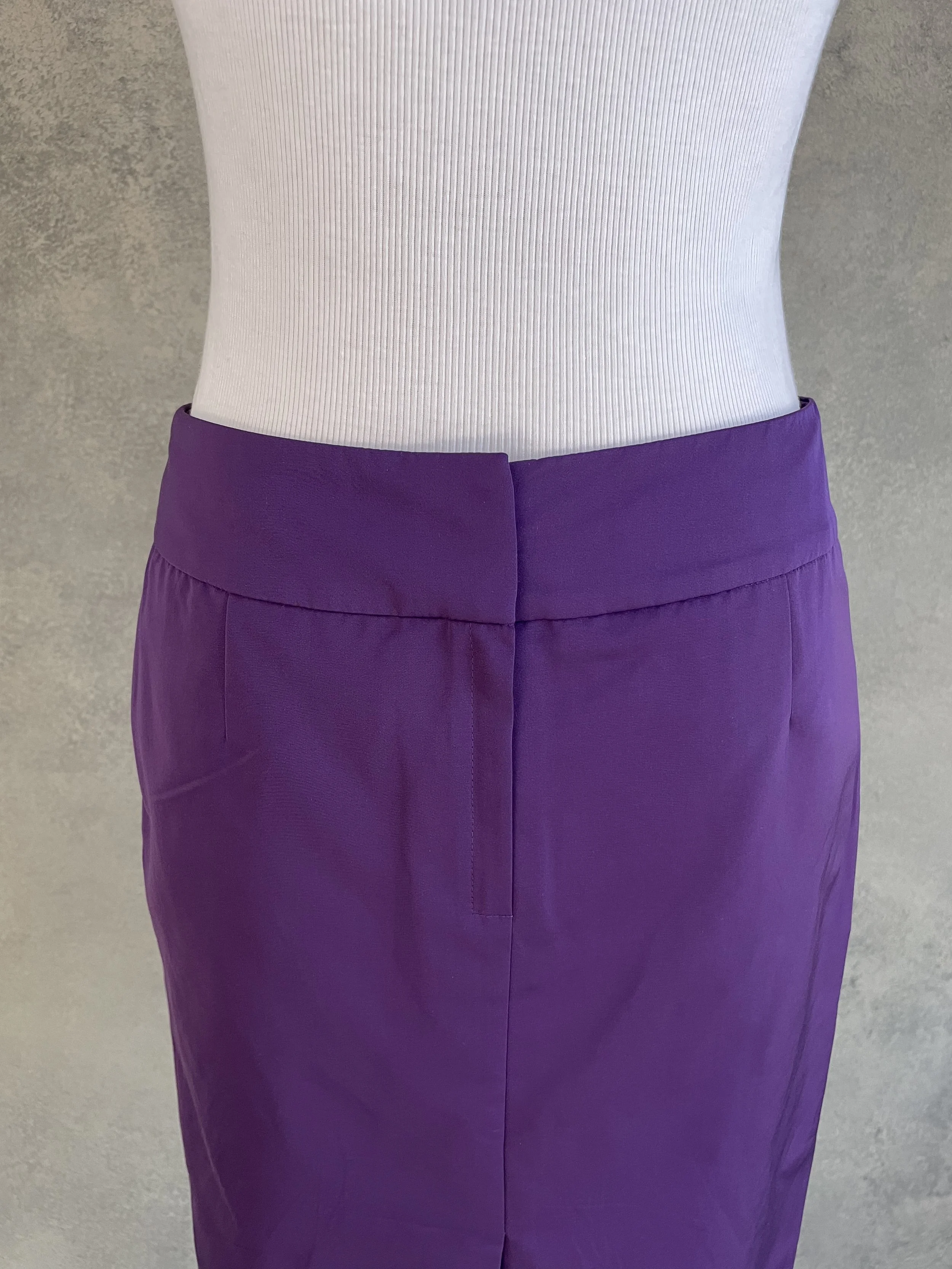 Detailed close-up of the waistband and clean front construction of the purple skirt.