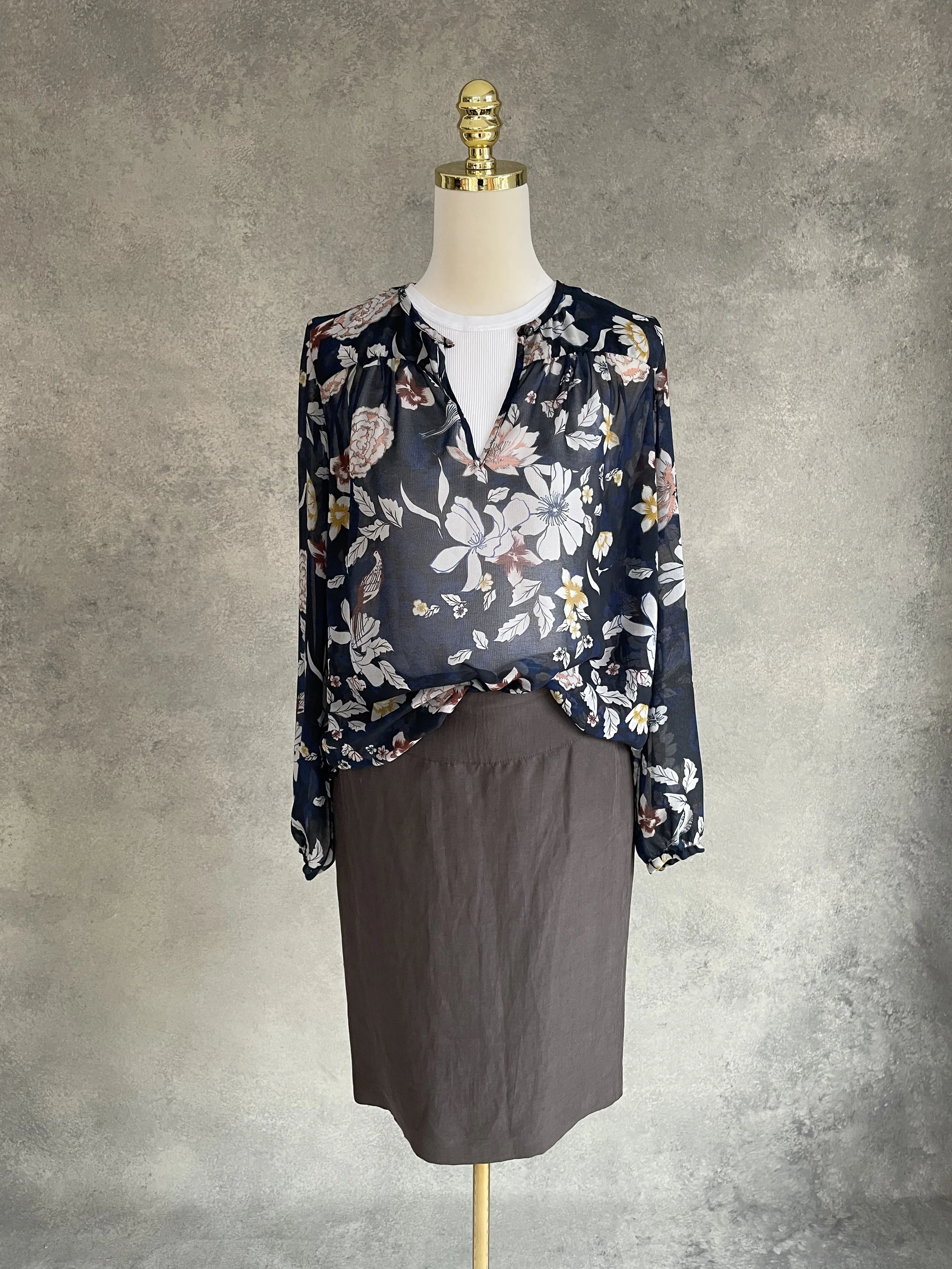 Mannequin wearing the Armani Collezioni brown skirt paired with a Gigue floral-print blouse in navy tones.