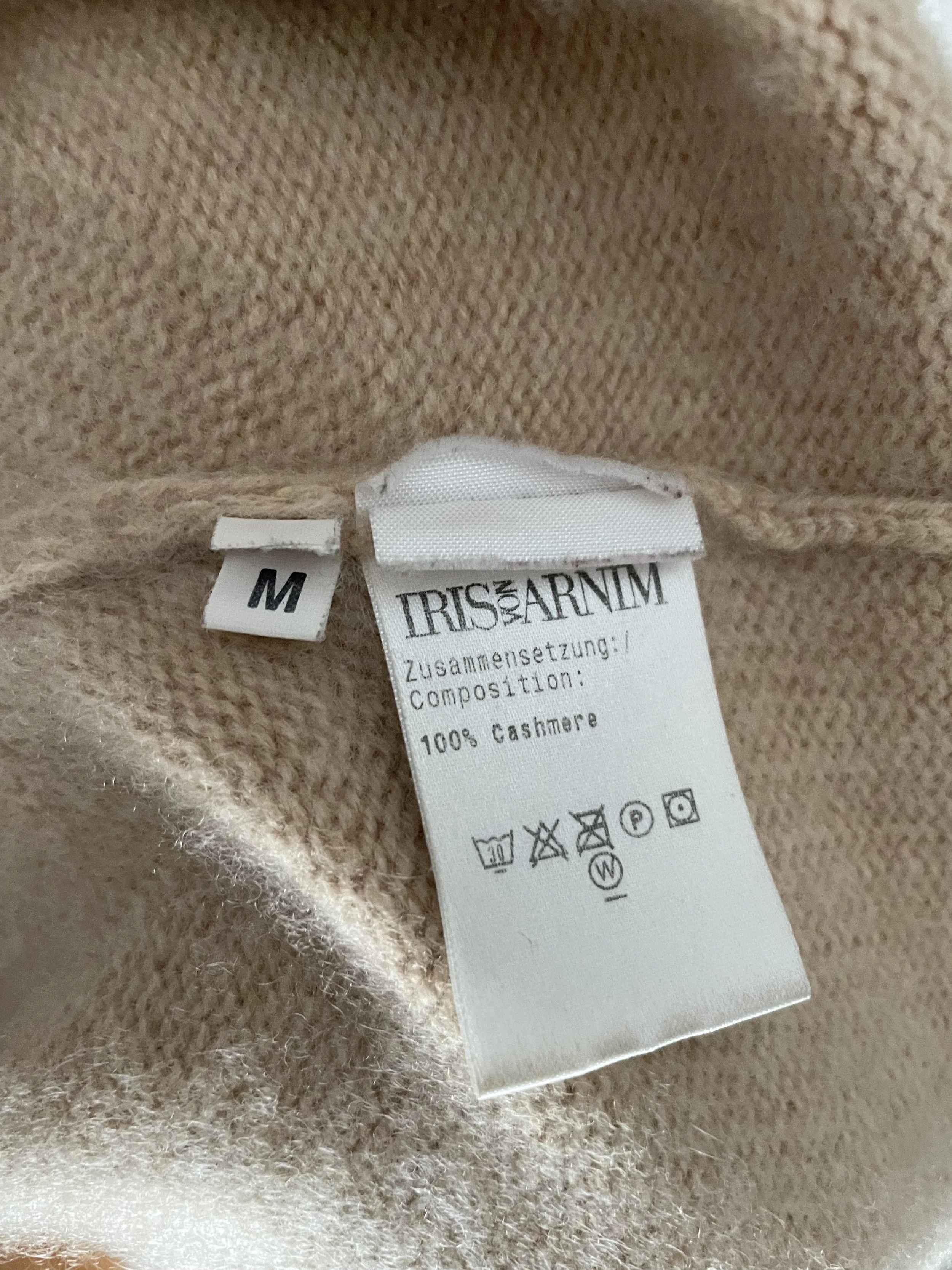 Detail view of the interior label on the Iris von Arnim garment, confirming 100% cashmere composition and size M.