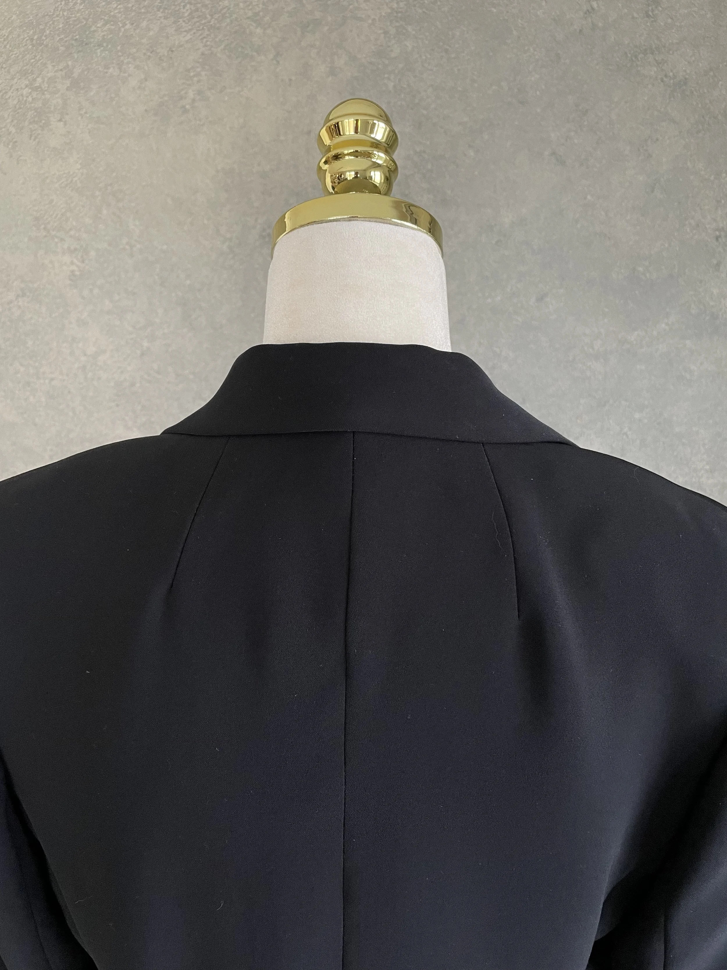 Close-up of the collar and shoulder area of the black blazer.