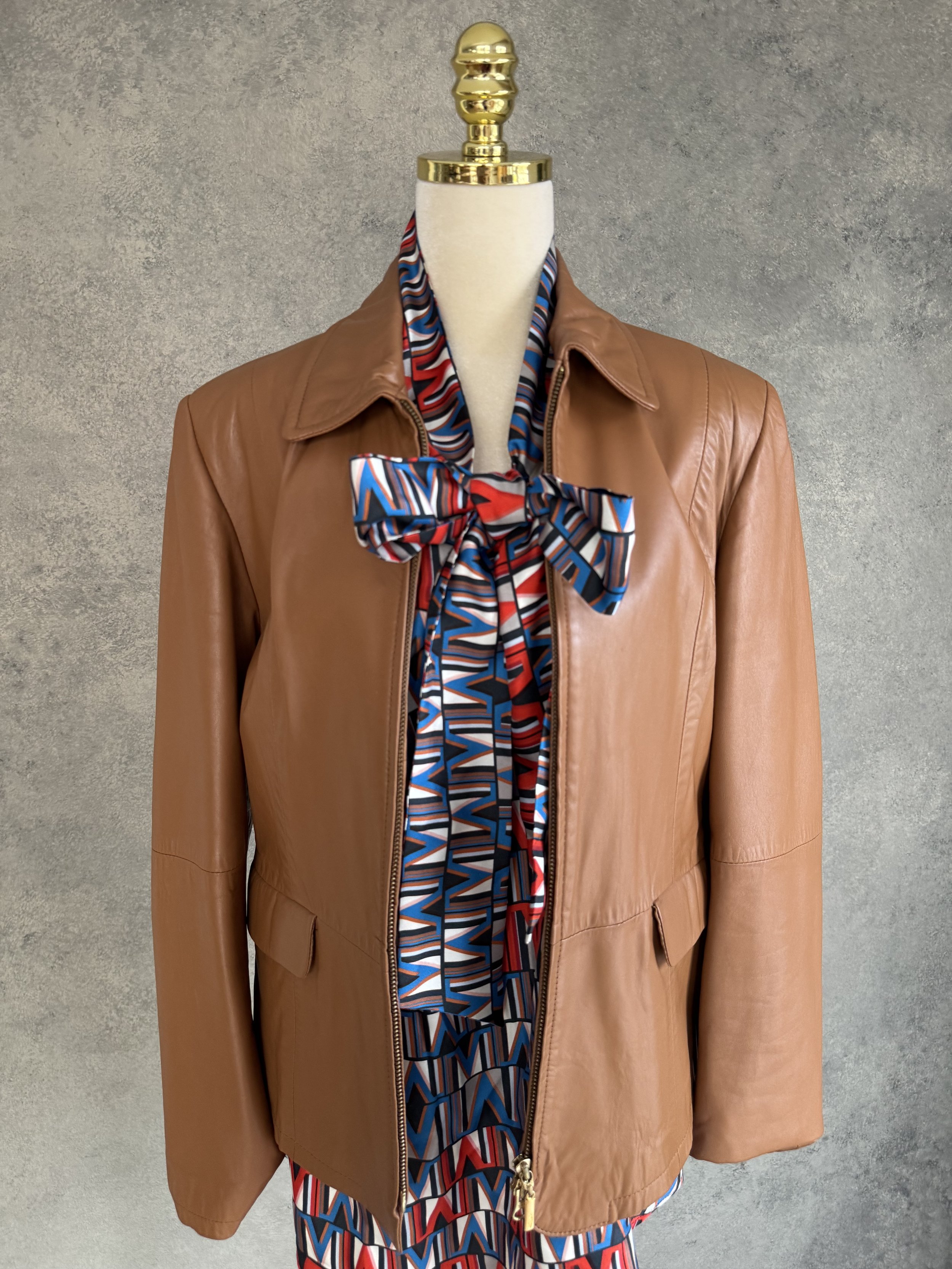 100% silk geometric print blouse styled under a premium brown leather jacket.