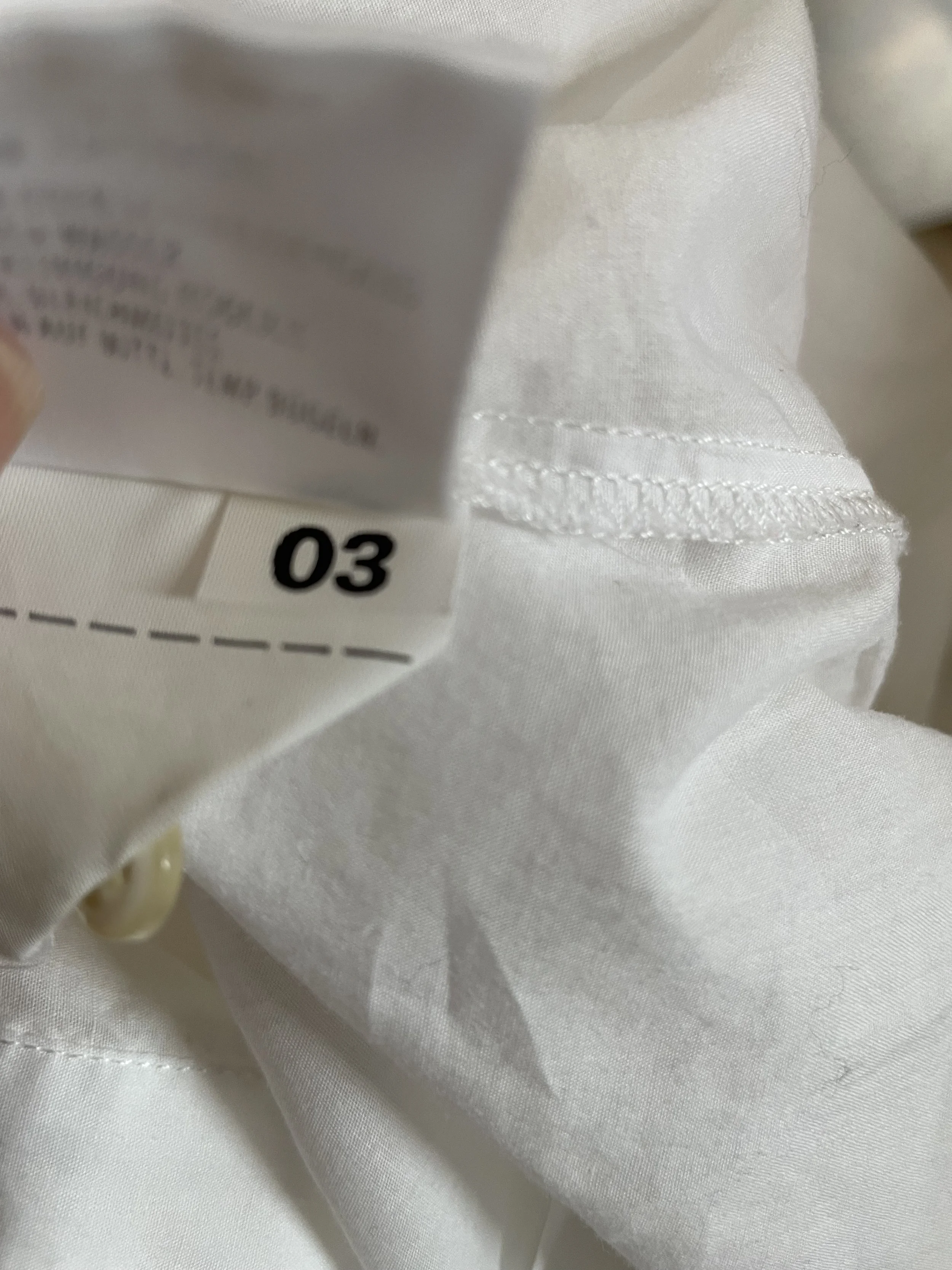 Close-up of the size '03' tag inside the shirt."