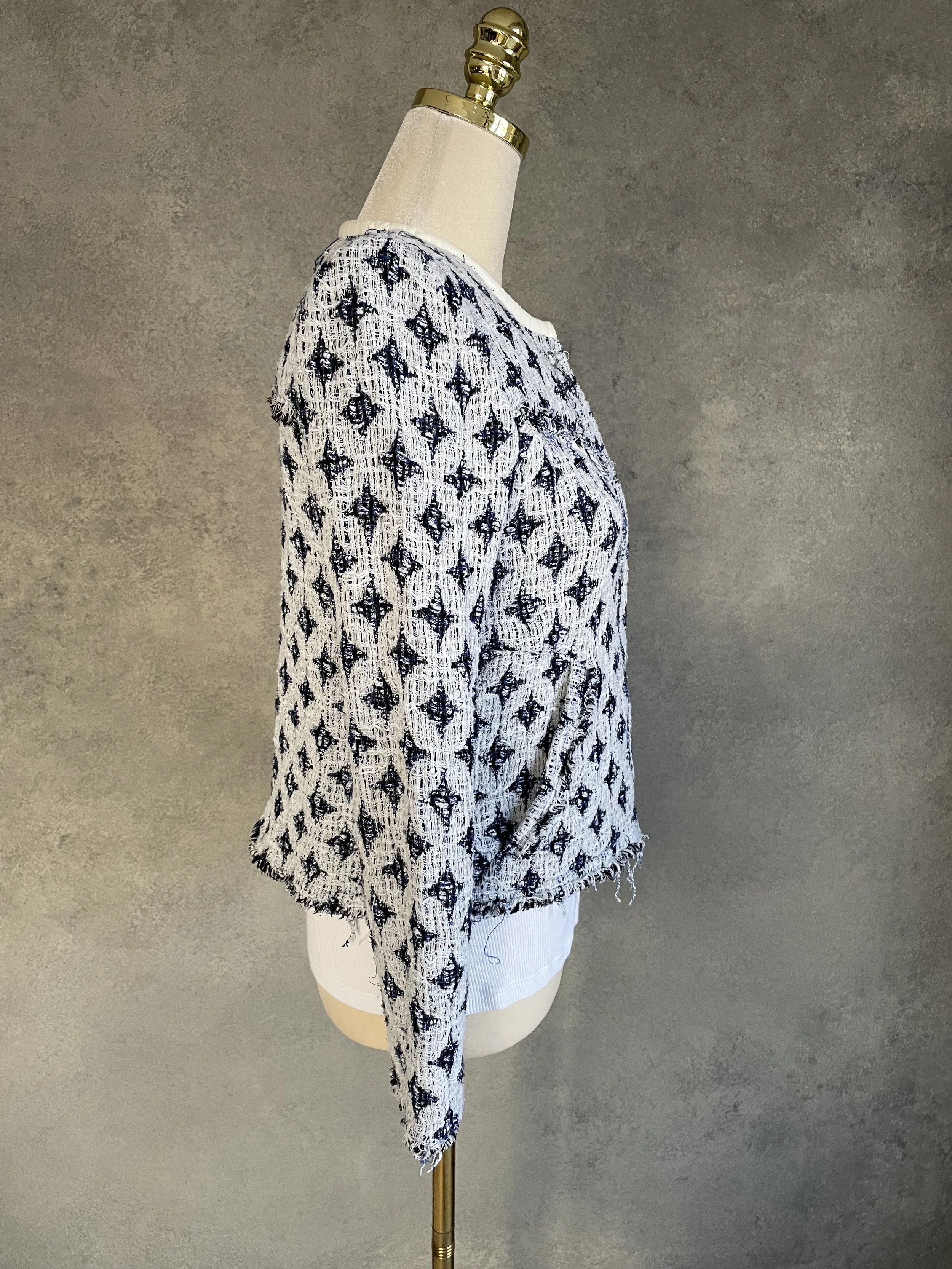 Side profile view of the IRO tweed jacket on a mannequin, showcasing the short length and tailored sleeve.