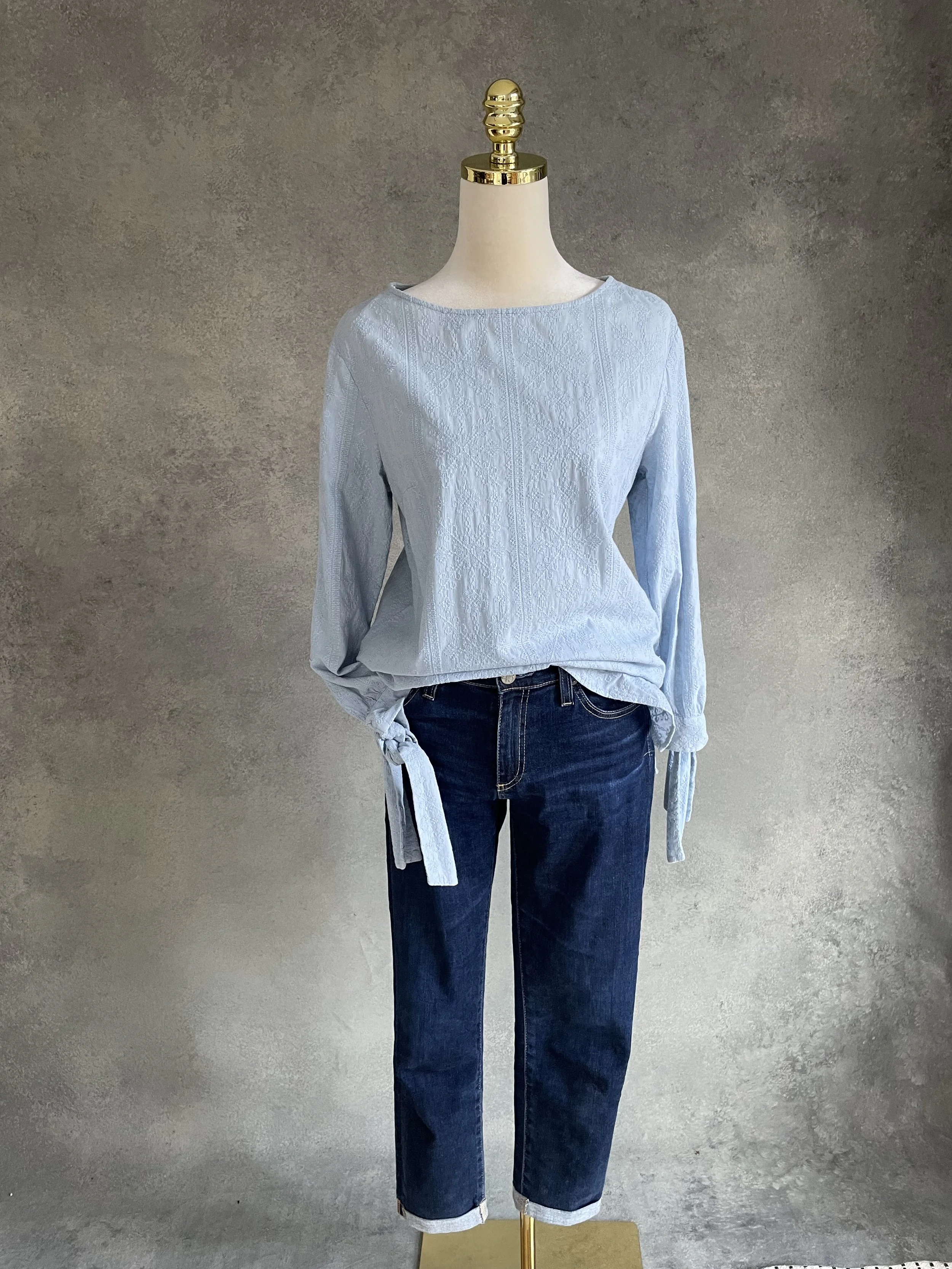 Blouse styled on a mannequin with blue jeans."