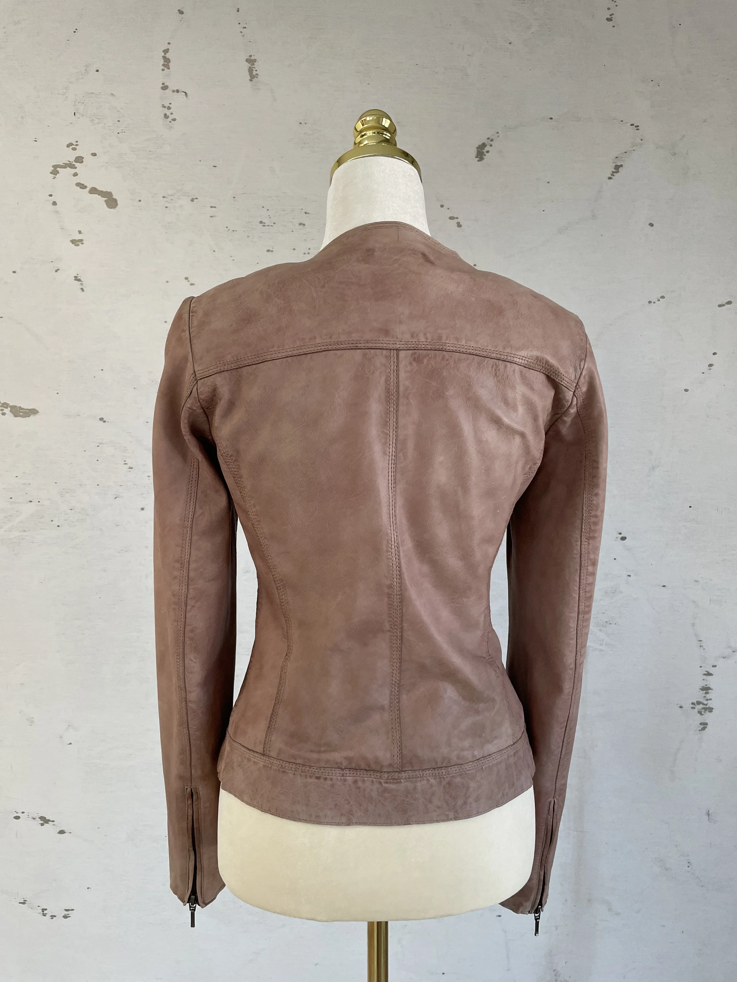 Back view of a Dusty rose leather jacket sitting on a mannequin