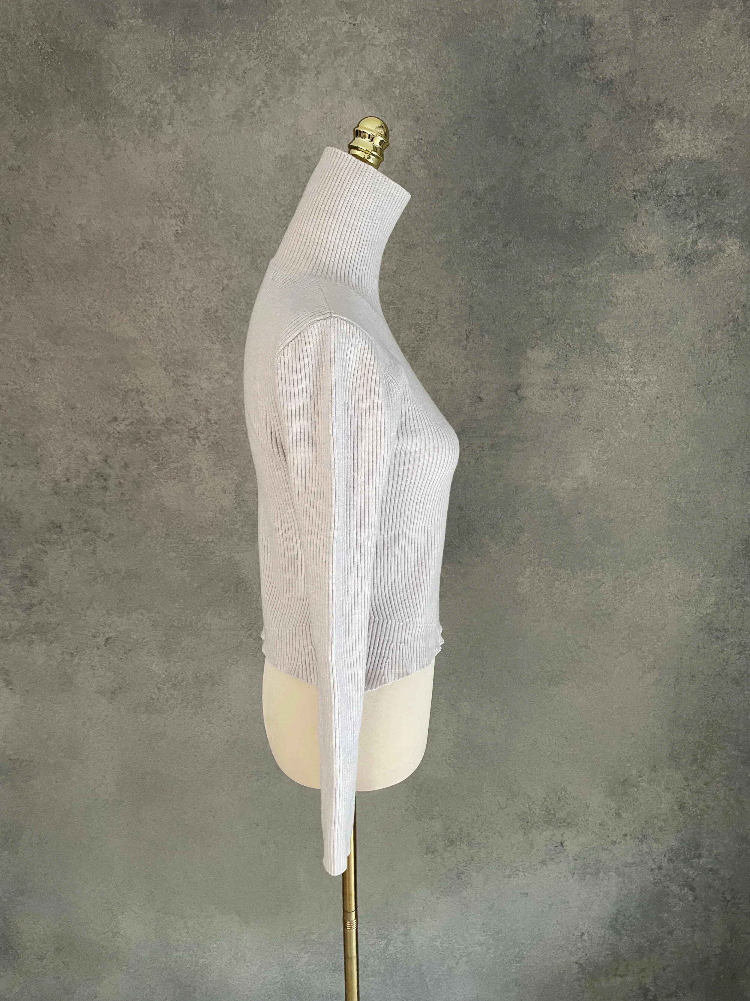 Side profile view of the grey Rodebjer poloneck, displaying the flattering fit and subtle peplum flare.