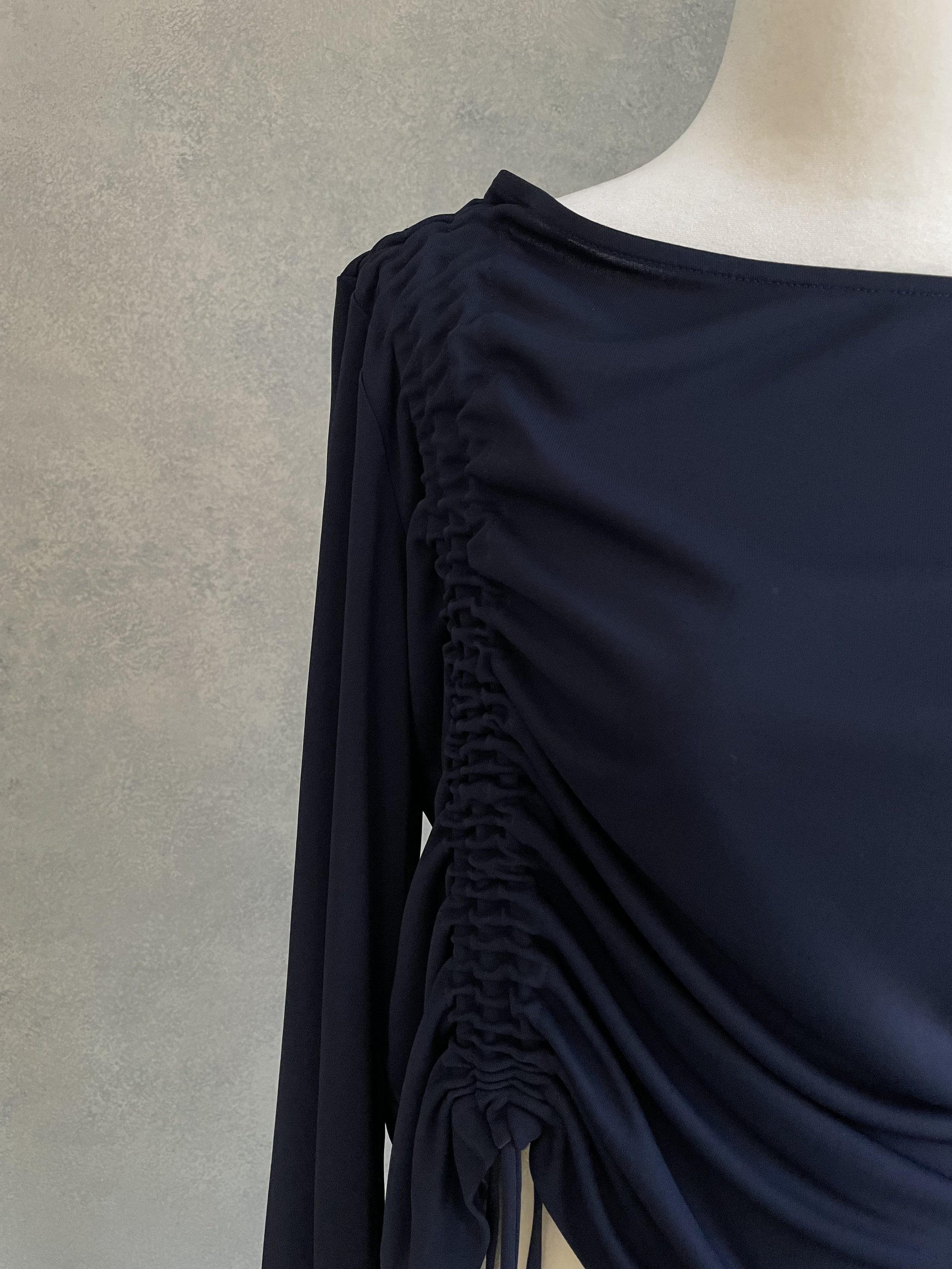 Close-up of the intricate side-tie and ruching detail on the navy blue BLANCHE top.