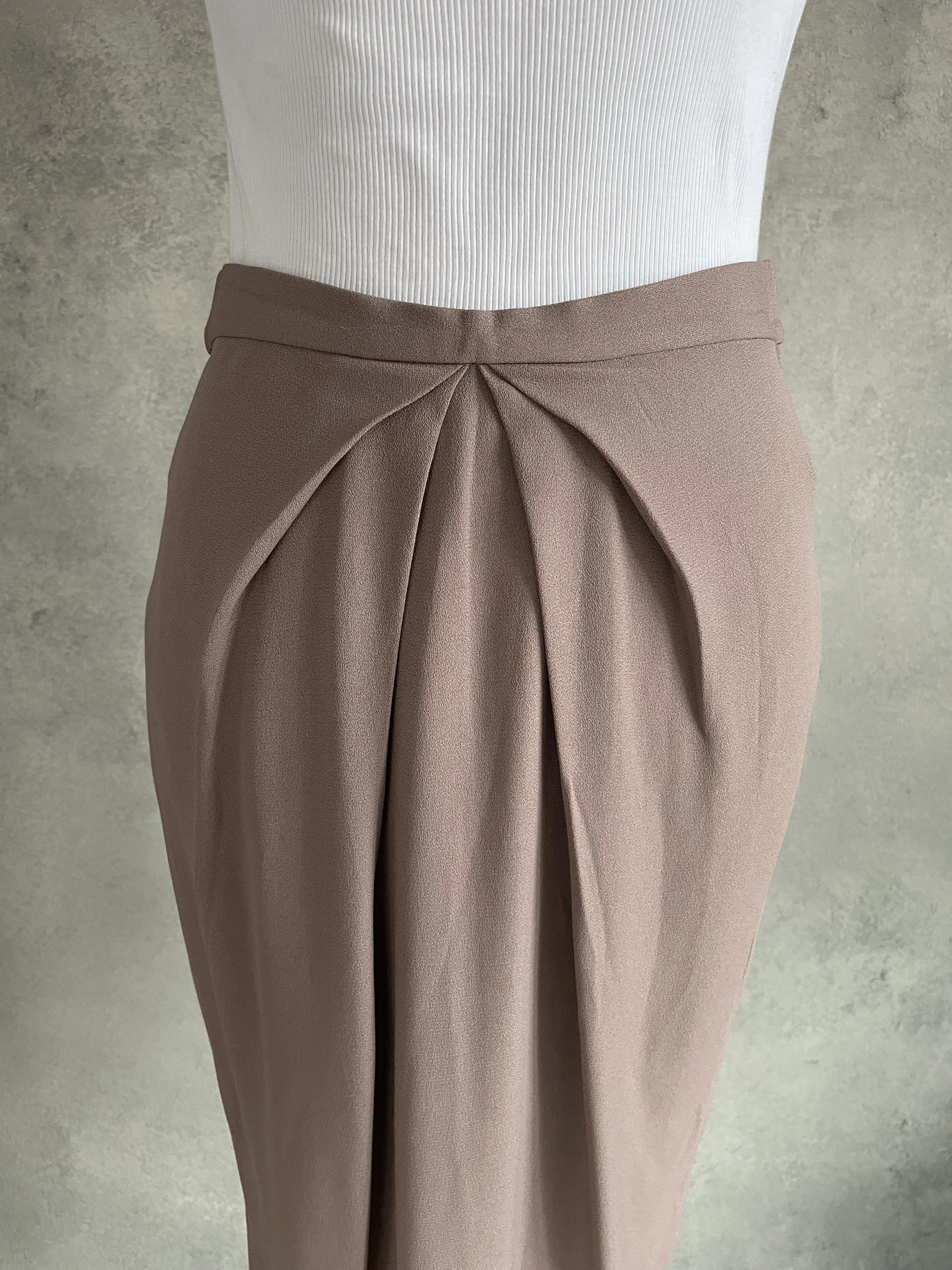 Close-up of Natan skirt waist detailing and pleated fabric texture.