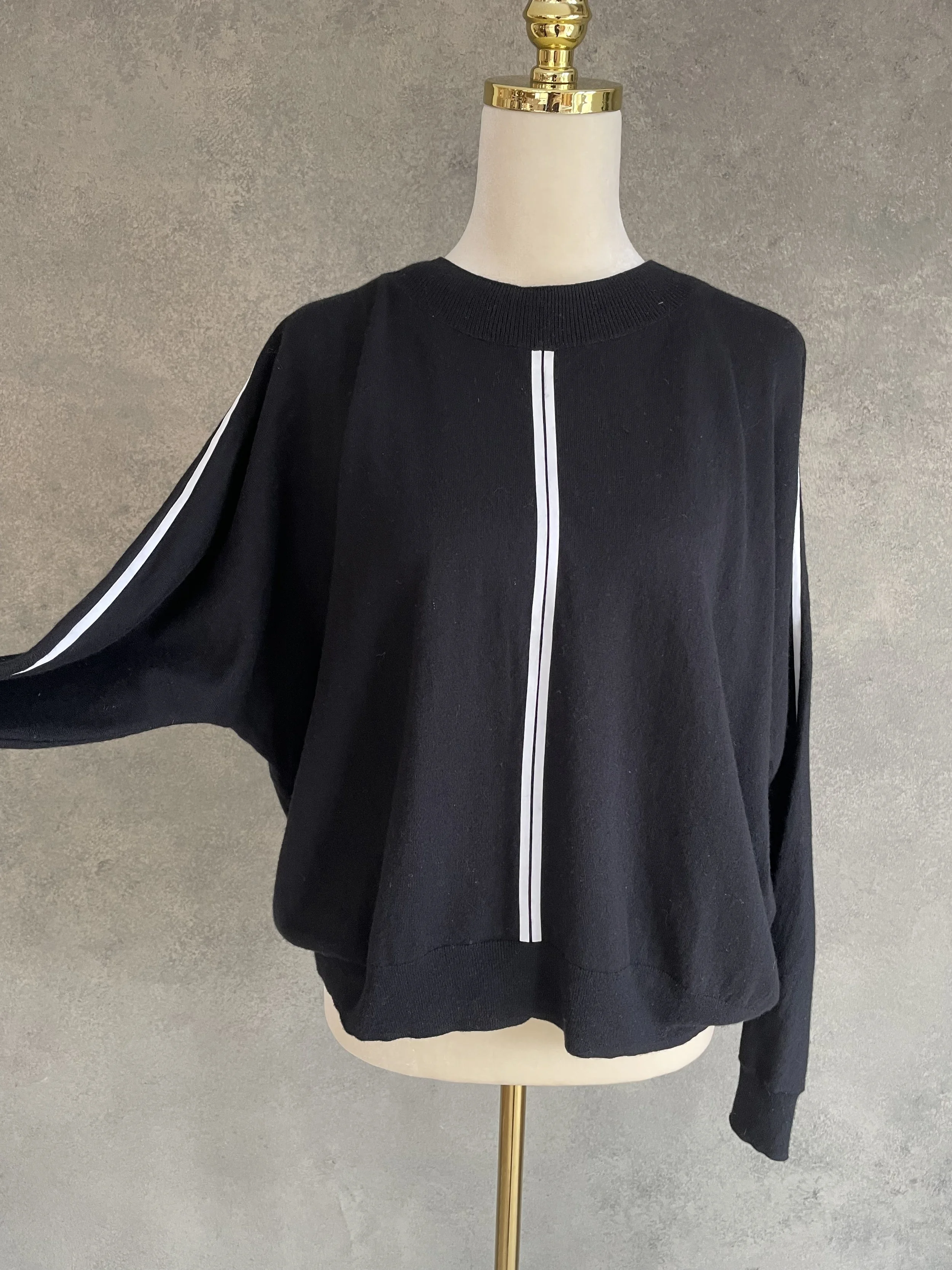Side view of Marc Cain bat-wing jumper on a mannequin, highlighting the voluminous sleeve silhouette and soft knit texture.